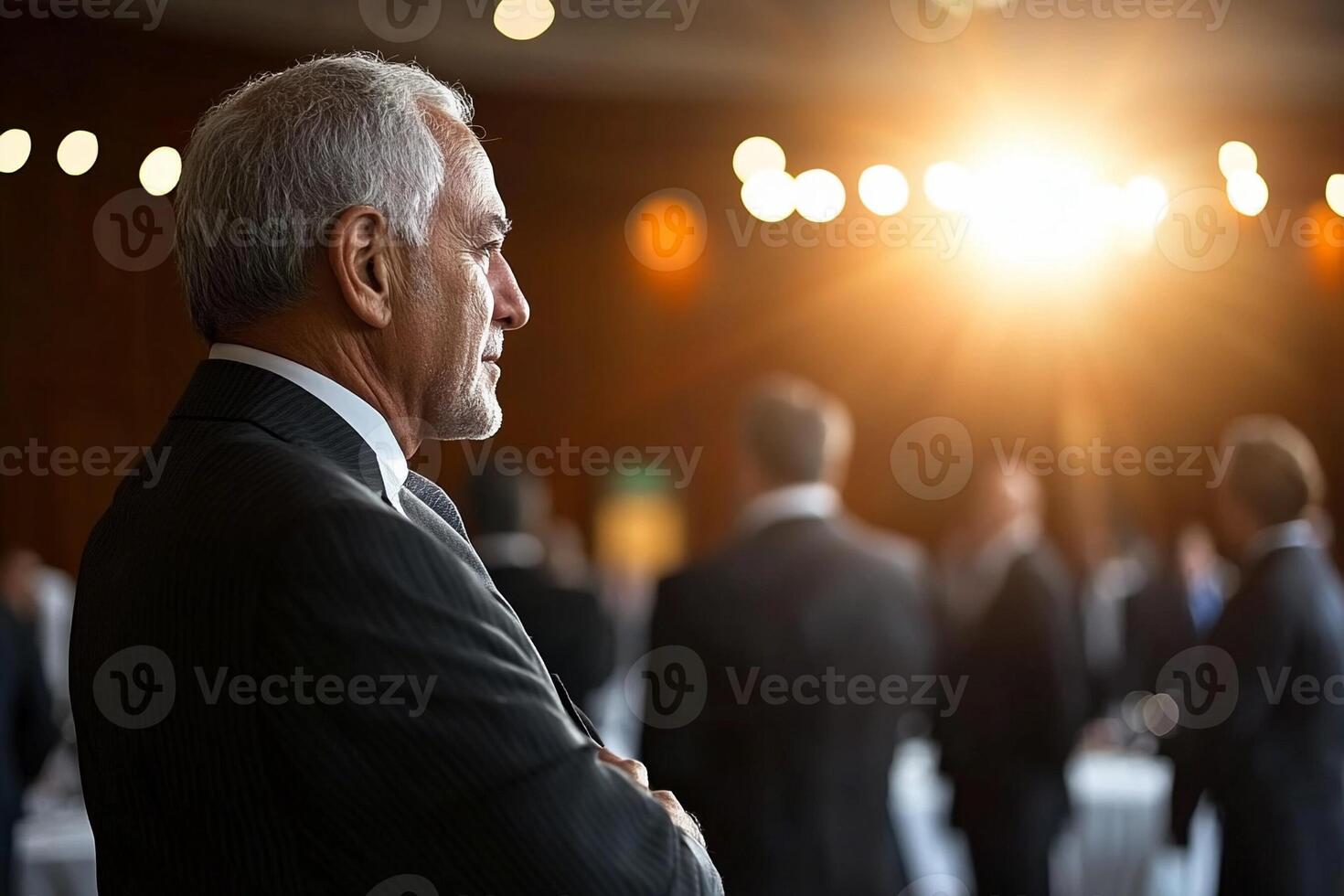A man in a suit stands in front of a group of people photo