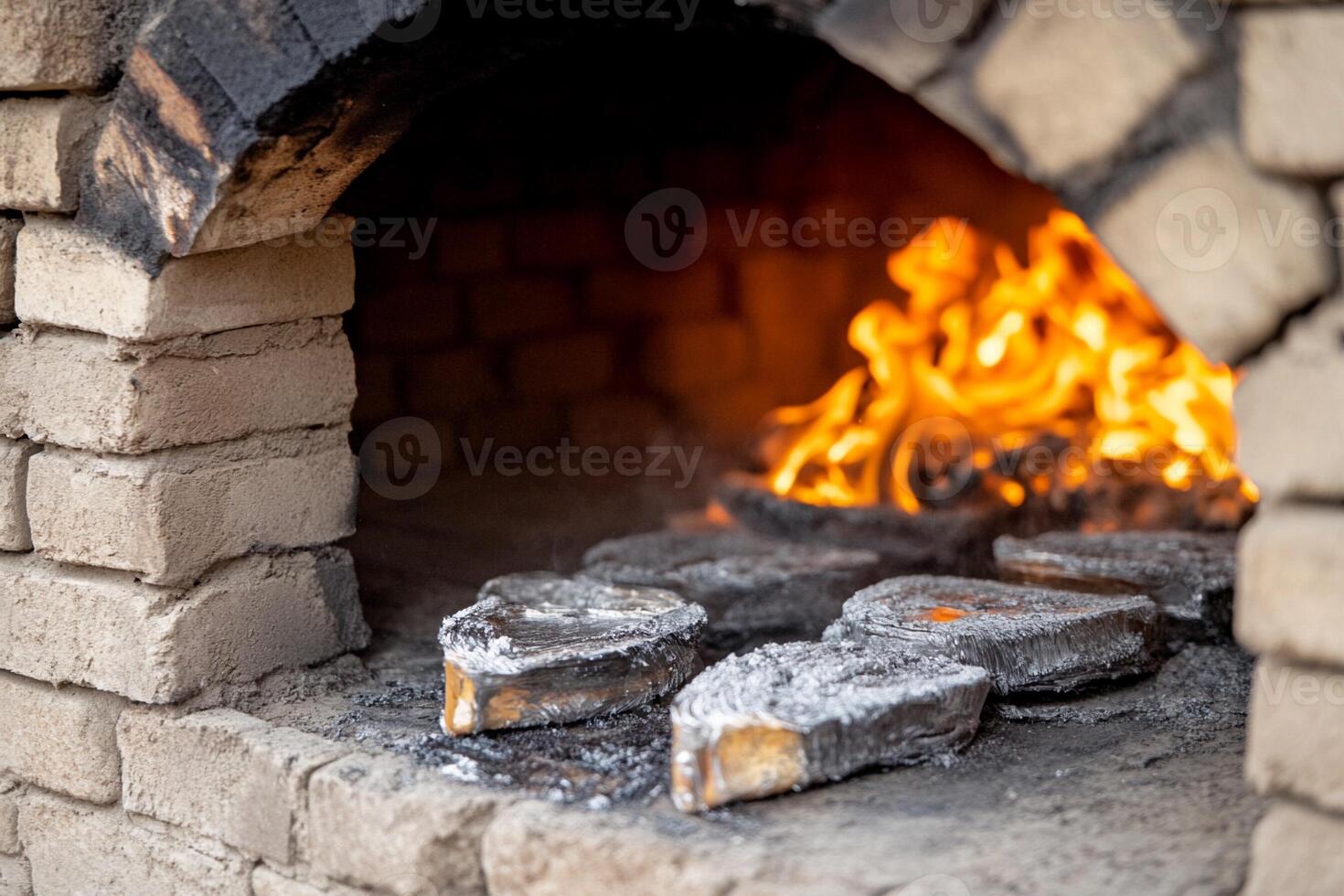 A brick oven with fire and wood photo