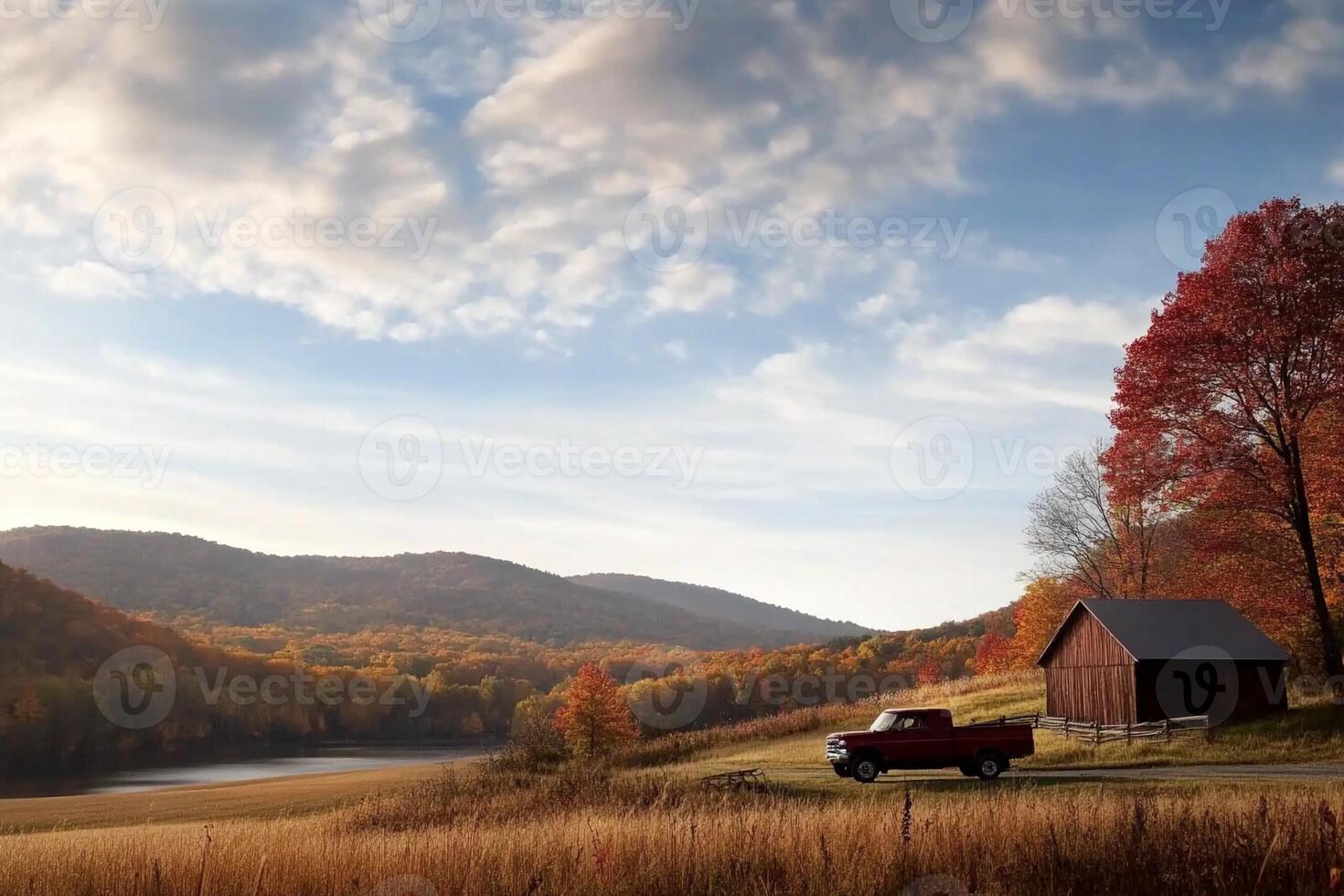 A red truck parked in front of a barn and mountains photo