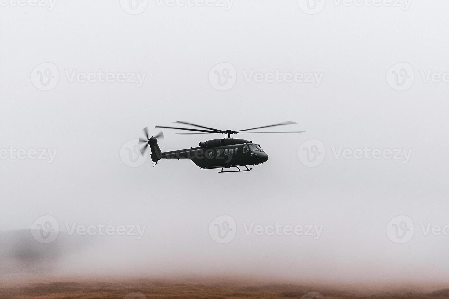 A helicopter flying through the fog on a mountain photo