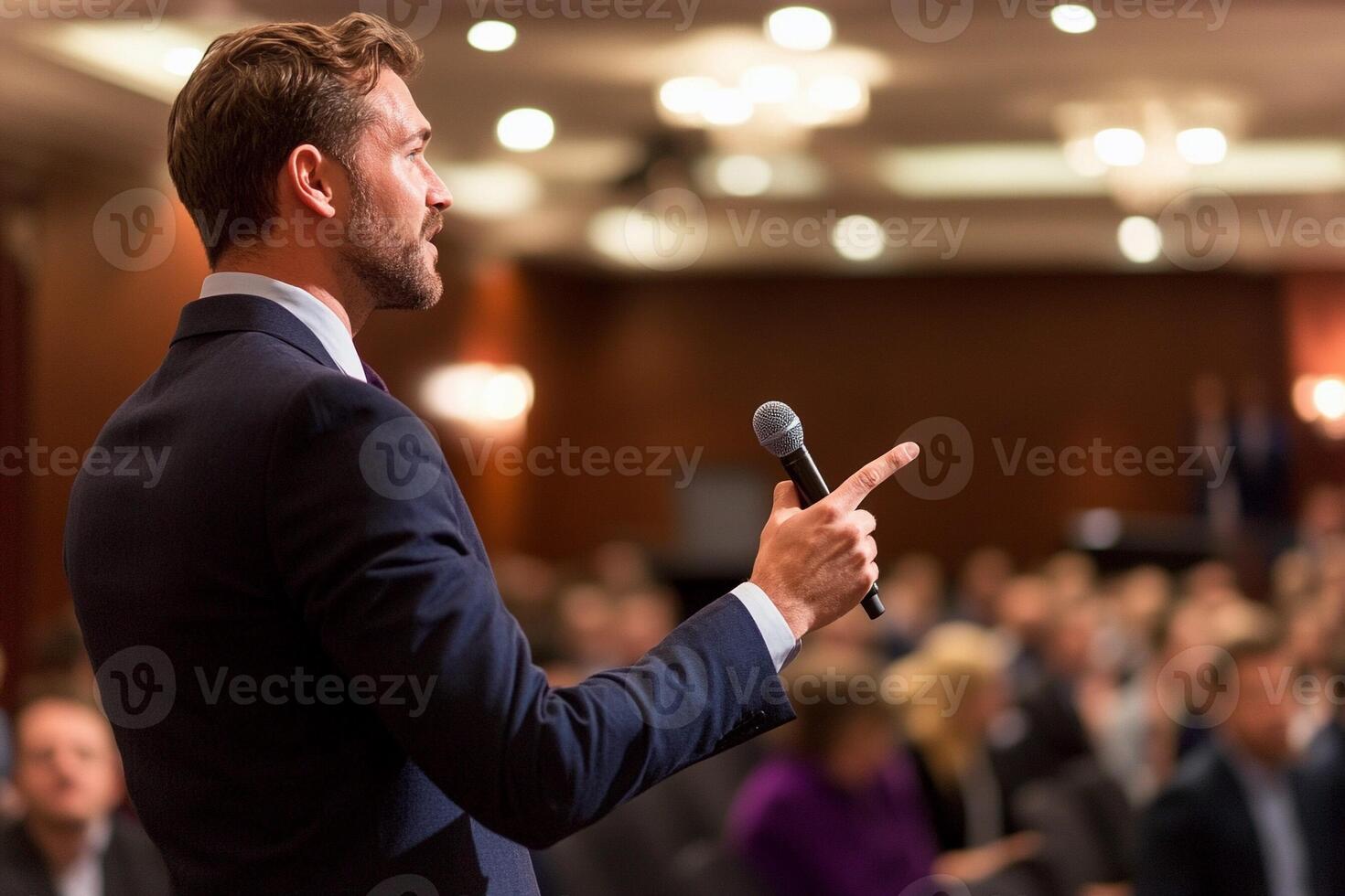 A man in a suit is giving a speech at a conference photo