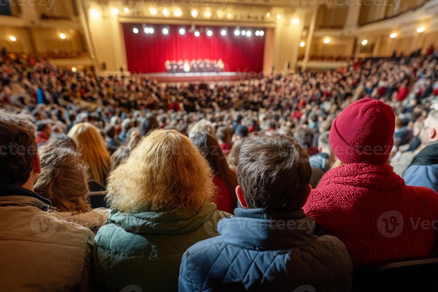 A crowd of people in a theater watching a performance photo