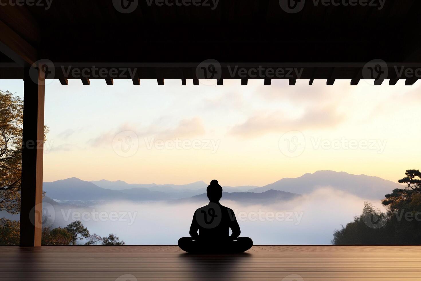A person sitting in meditation in front of a mountain view photo