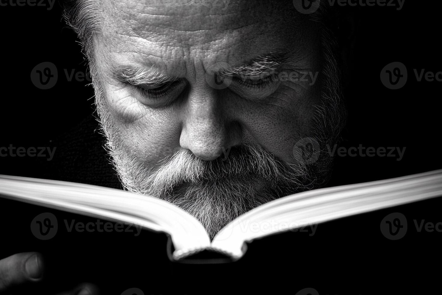 A man with a beard reading a book photo