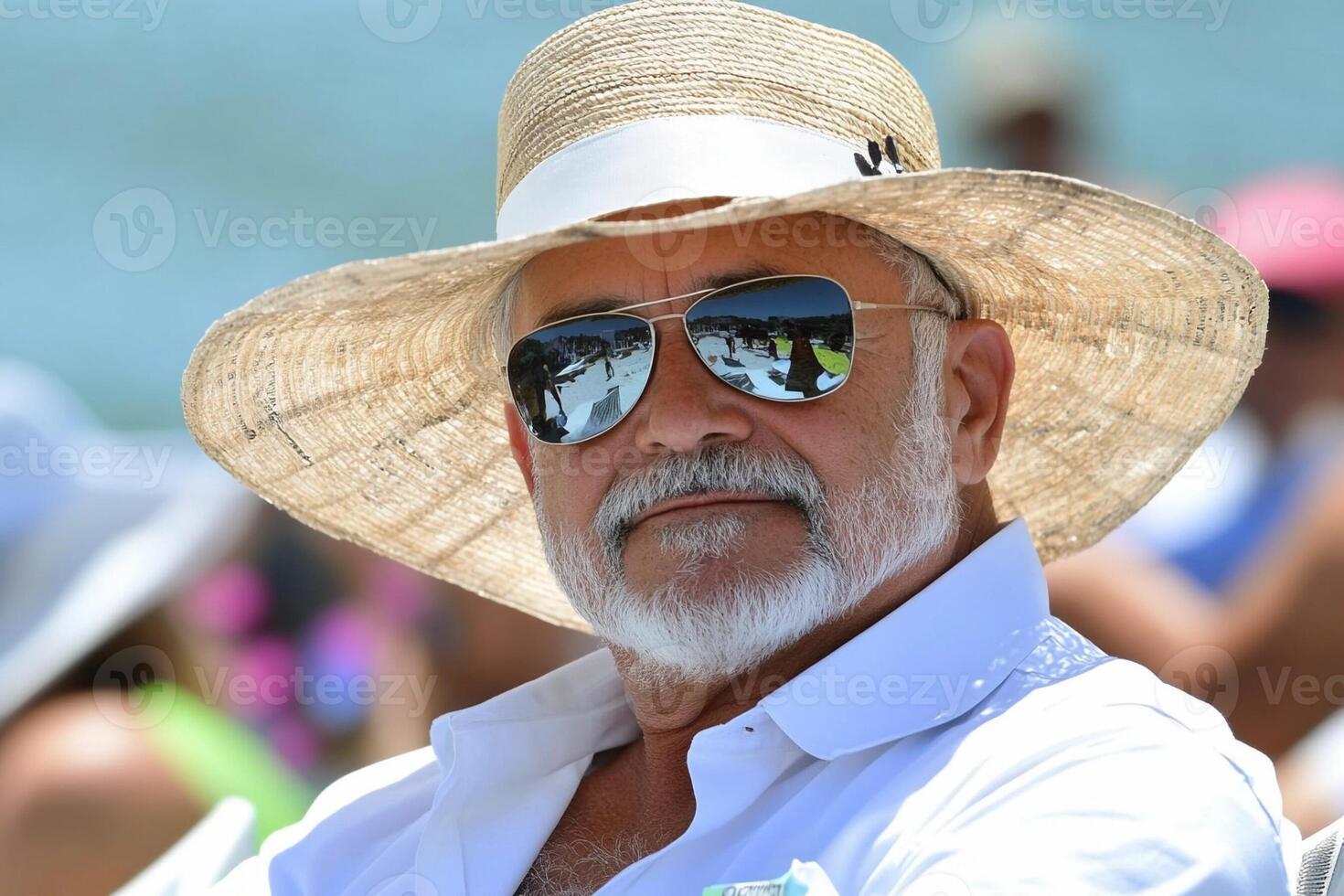 A man in a straw hat and sunglasses sitting in the sun photo