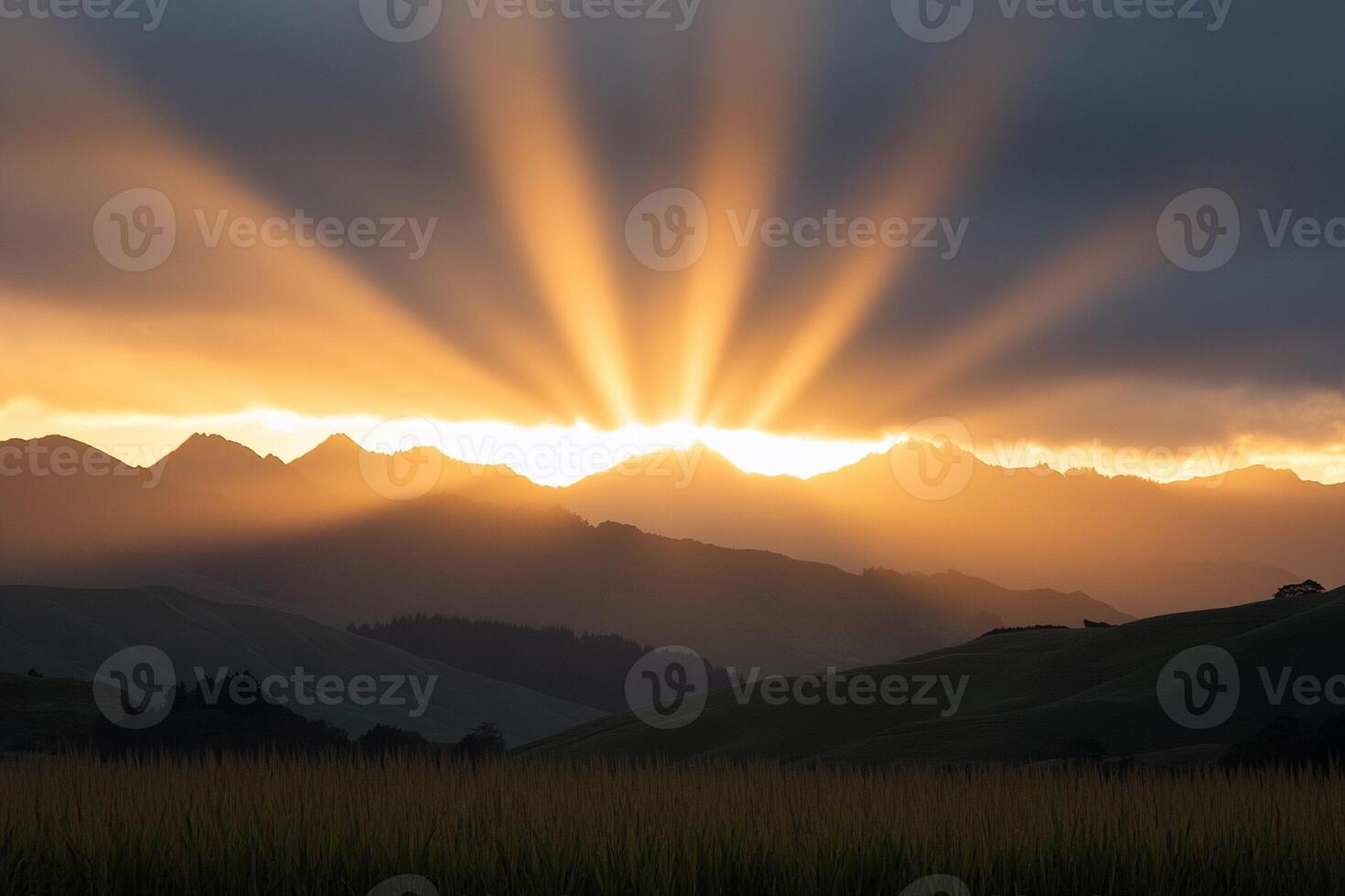 Sunbeams shine through the clouds over a mountain range photo