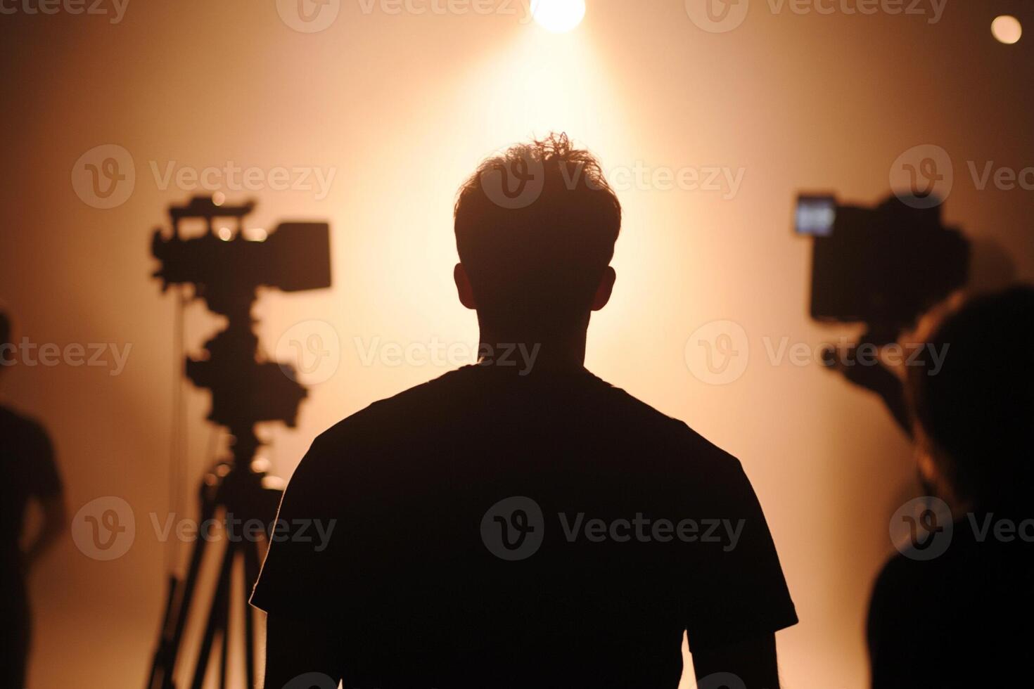 A man standing in front of a camera and a spotlight photo