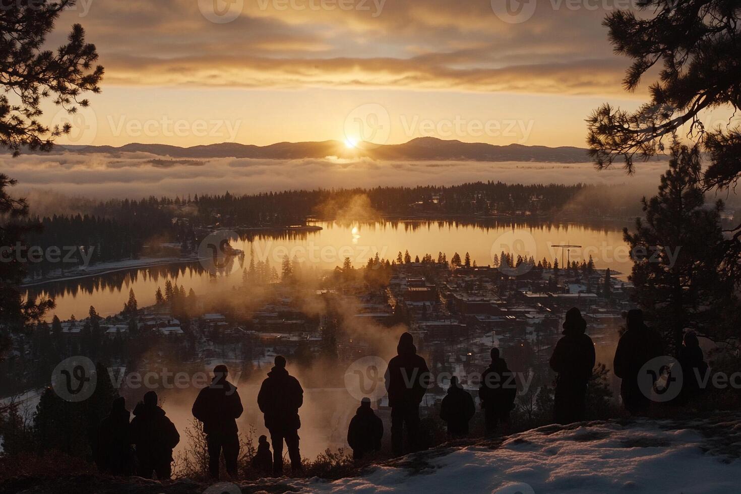 A group of people standing on a hill overlooking a lake photo