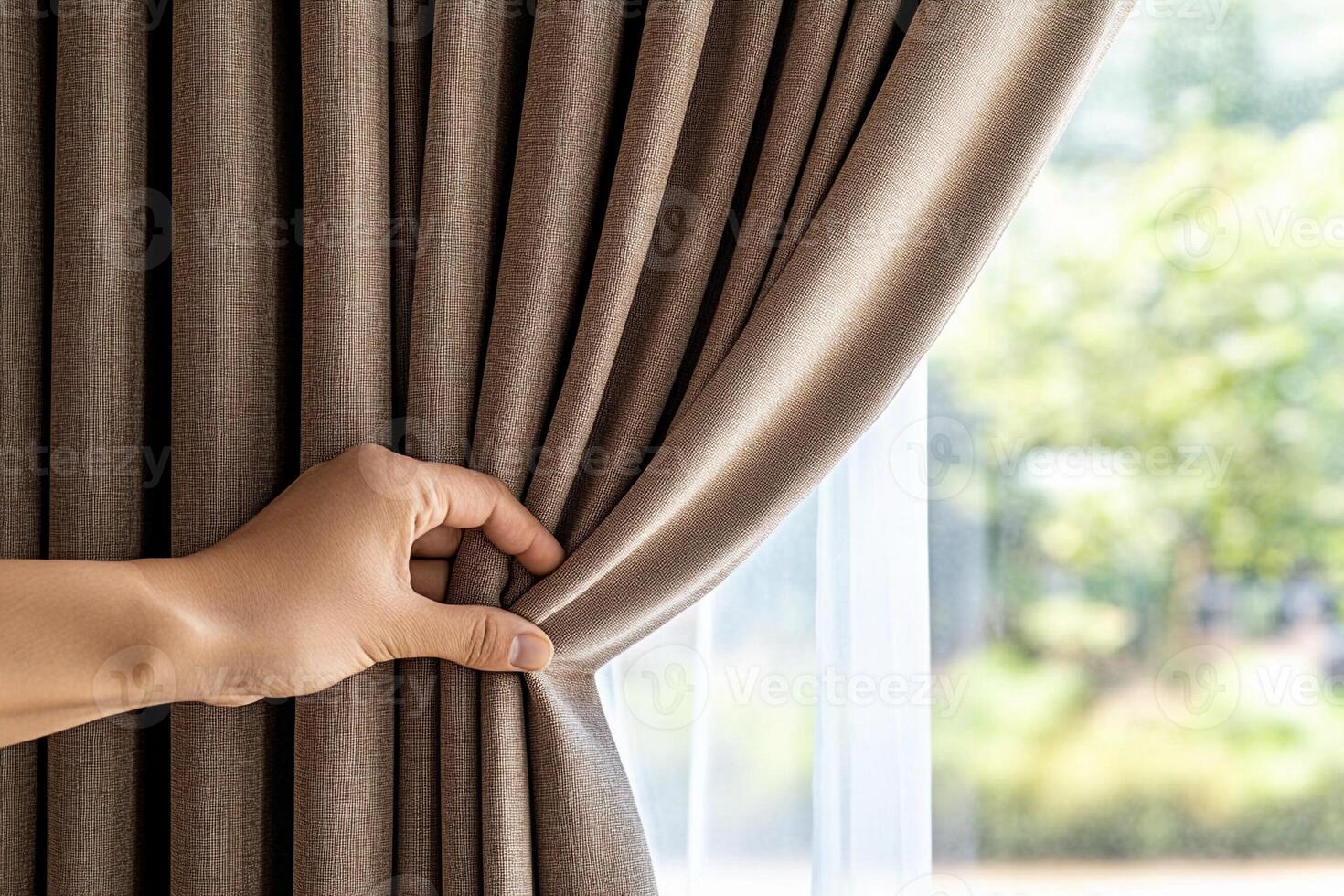 A person is opening a curtain to show the window photo