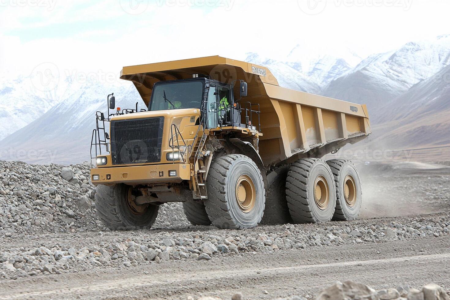 A large dump truck driving on a rocky road photo