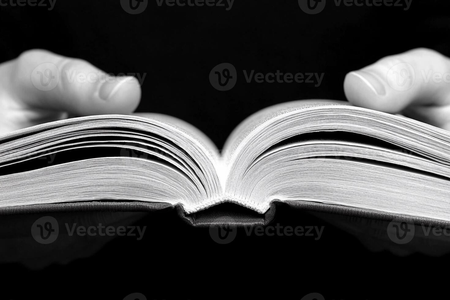 A person holding an open book in their hands photo
