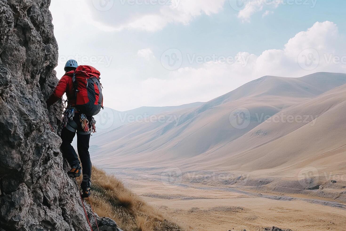 A man with a backpack climbing on a mountain photo