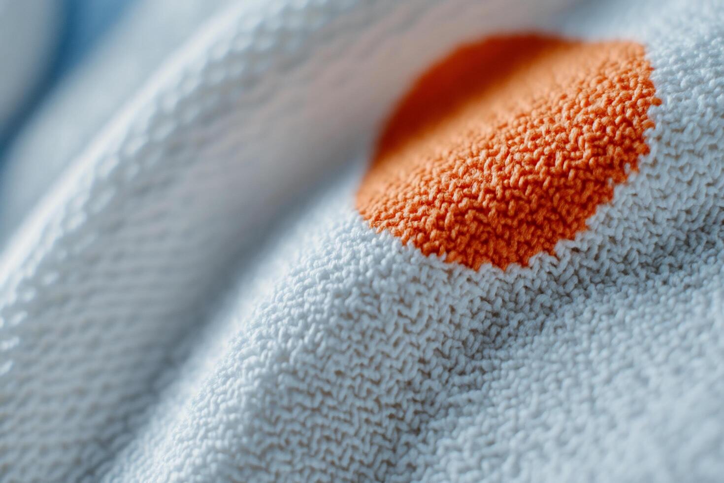A close up of a white towel with an orange dot photo