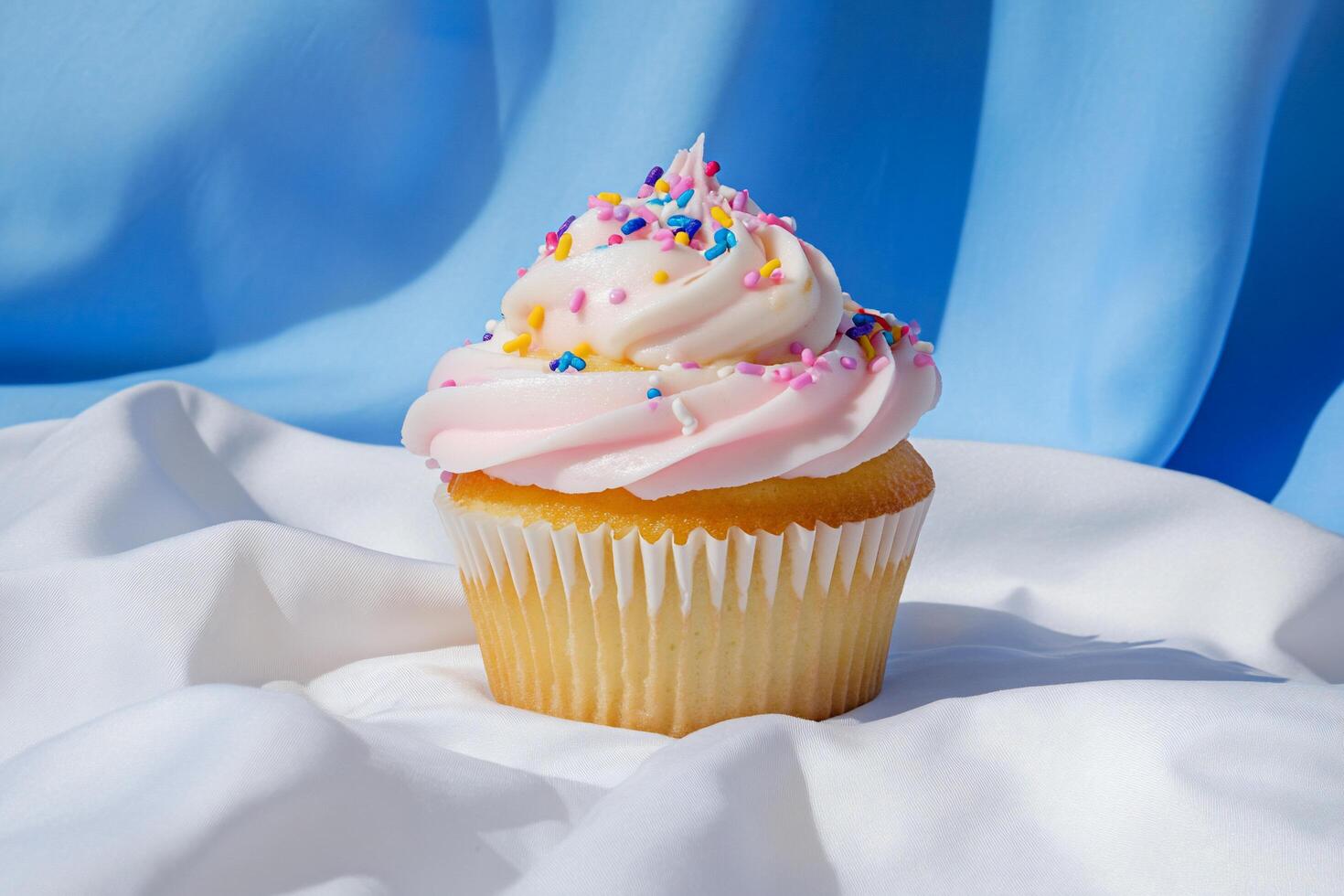 A delicious cupcake with pink frosting and colorful sprinkles. photo