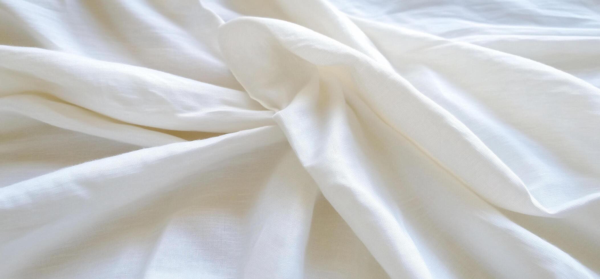 A close-up of soft, white fabric displaying gentle folds and texture. photo