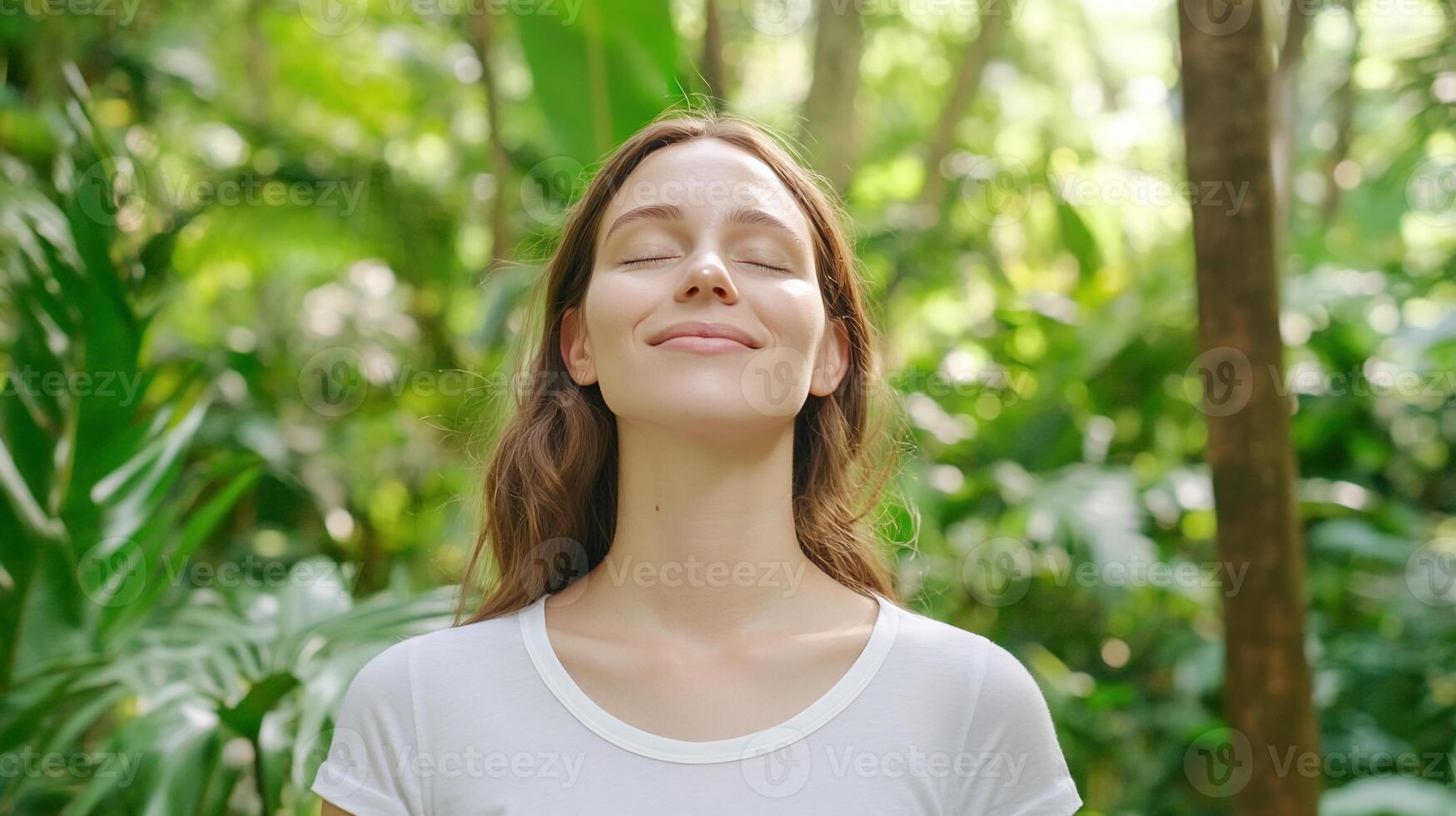 A woman is smiling in the middle of a forest photo