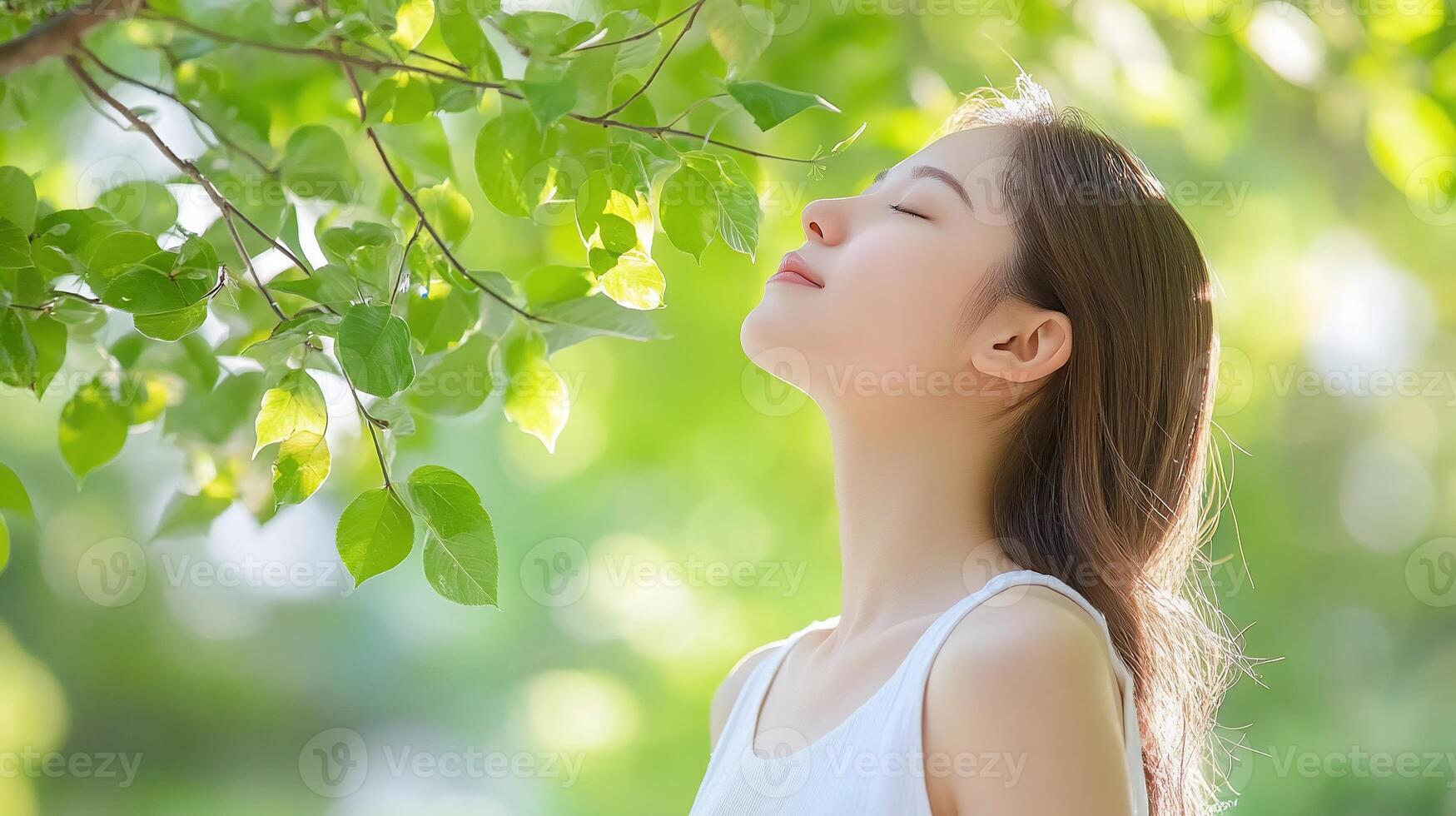 A woman is smelling the air from a tree photo