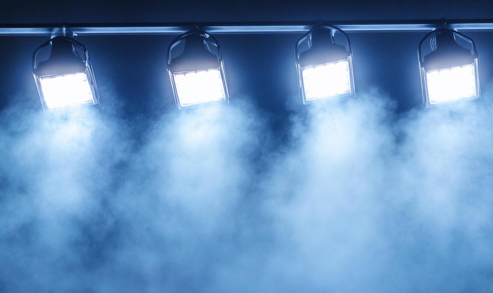 A group of four spotlights are on a stage photo