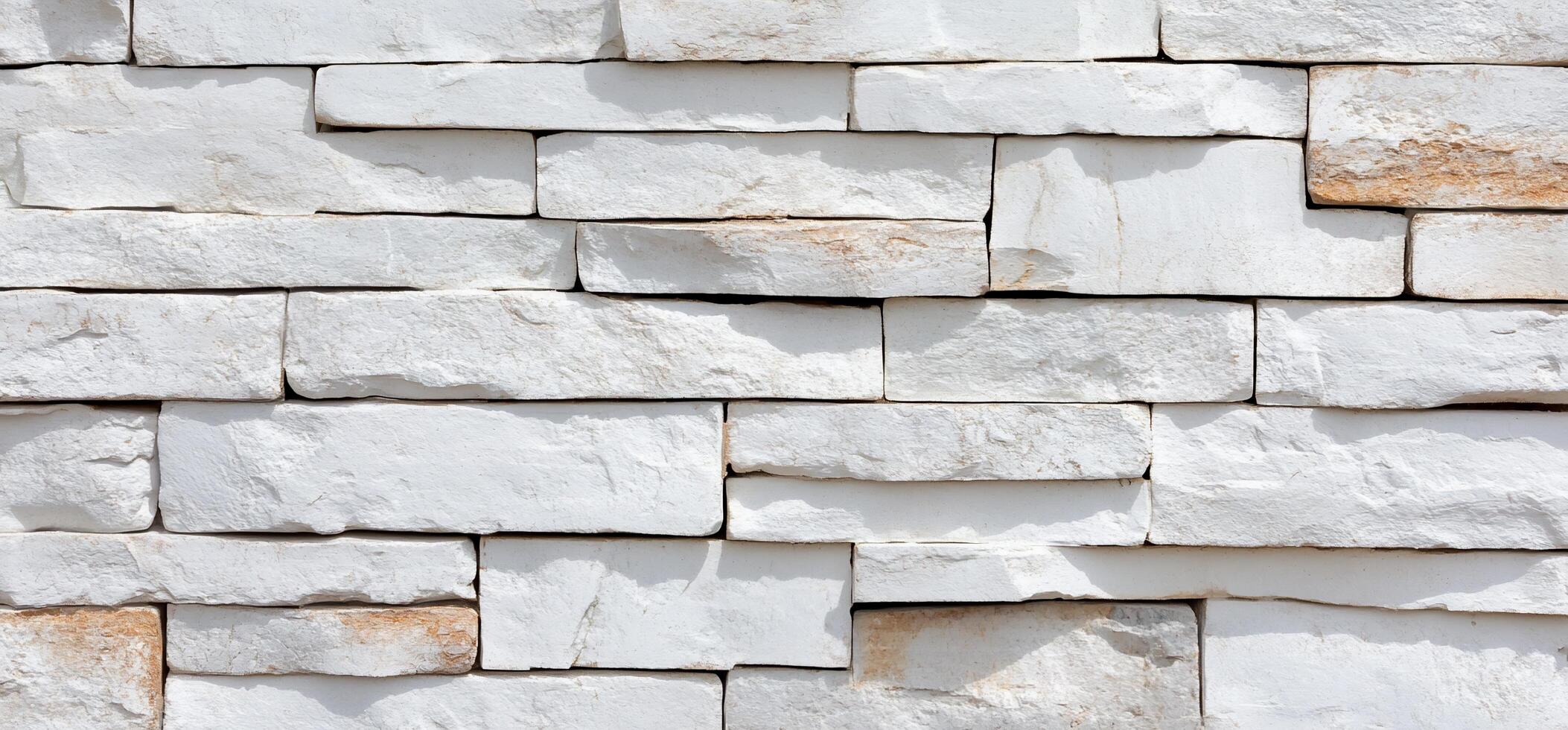 A textured wall made of white stone bricks arranged in a pattern. photo