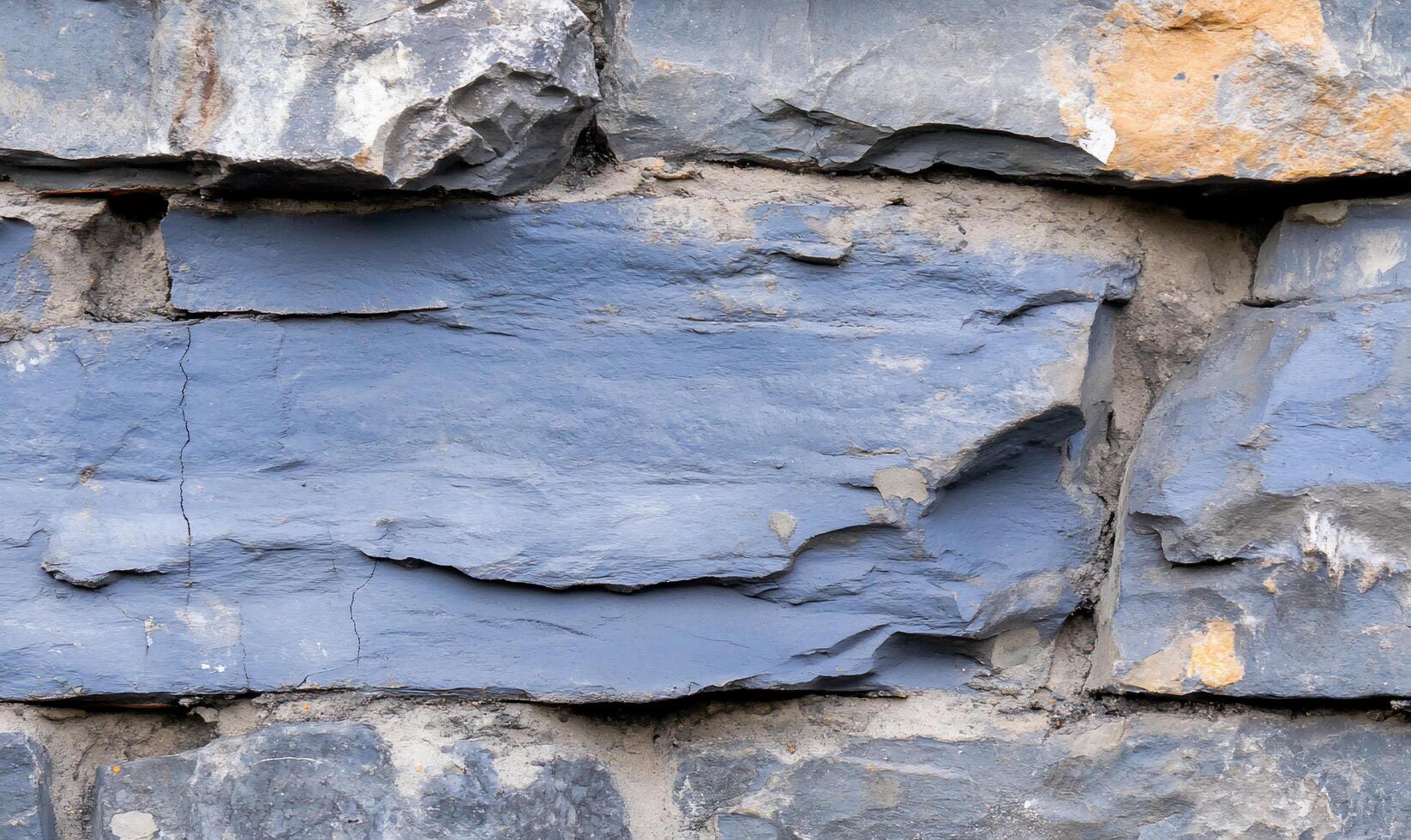 Close-up of layered slate rock with varying textures and colors. photo