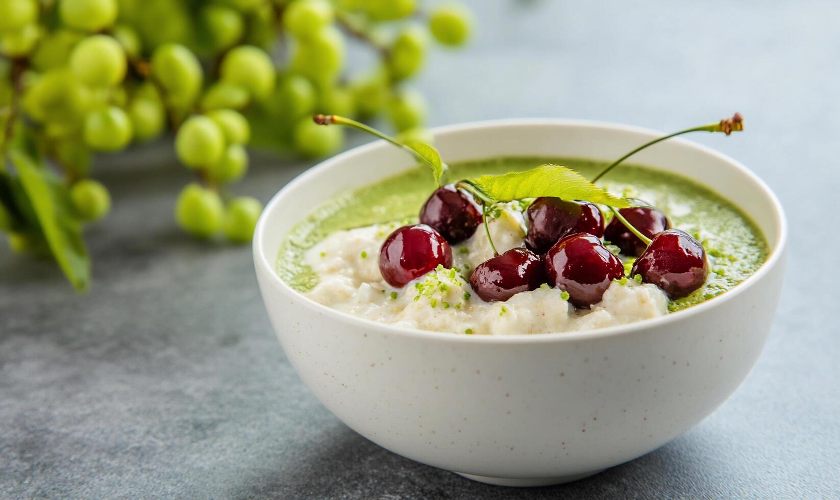 A bowl of green smoothie topped with cherries and cottage cheese. photo
