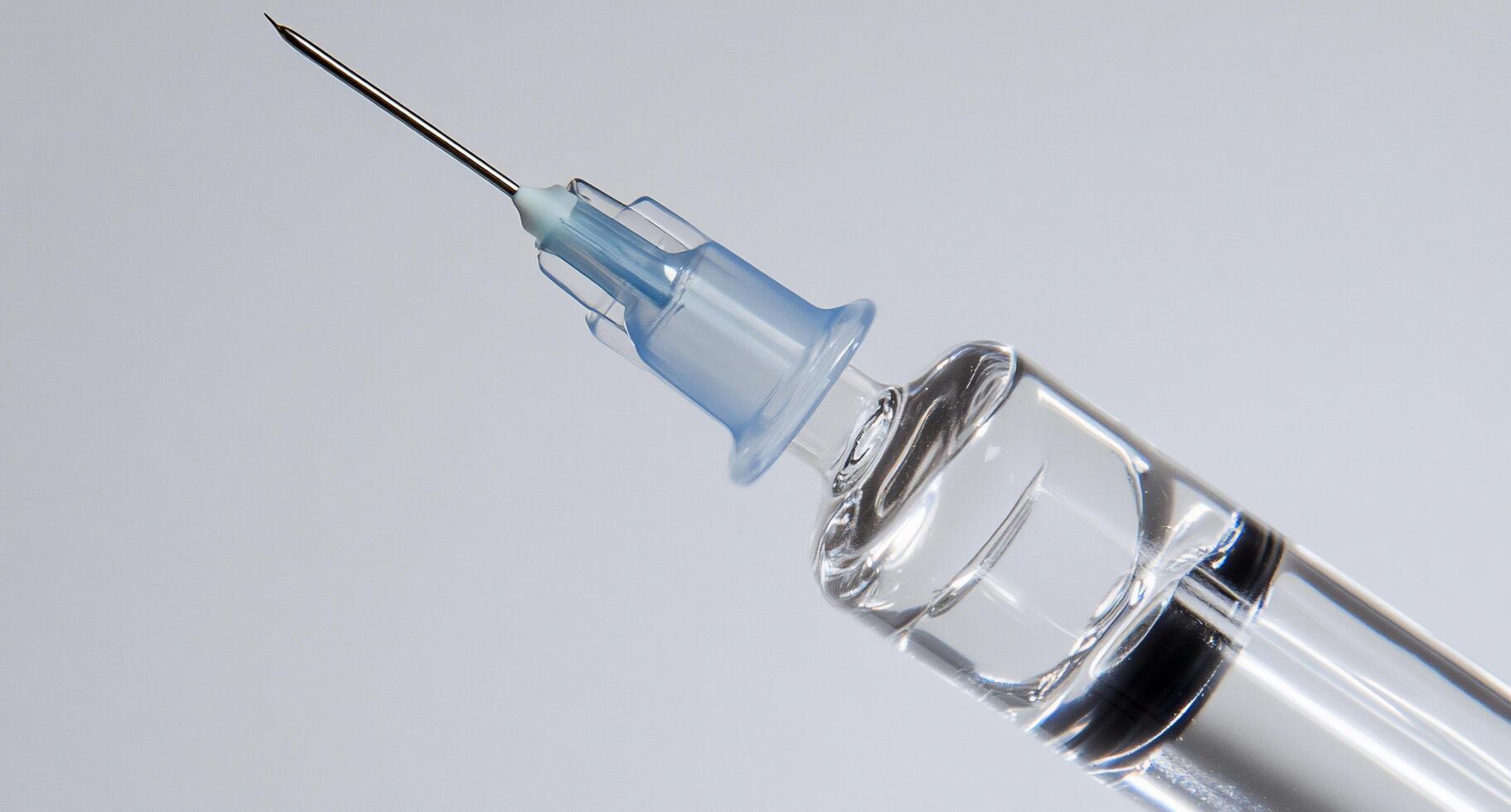 Close-up of a syringe needle with liquid, used for injections. photo