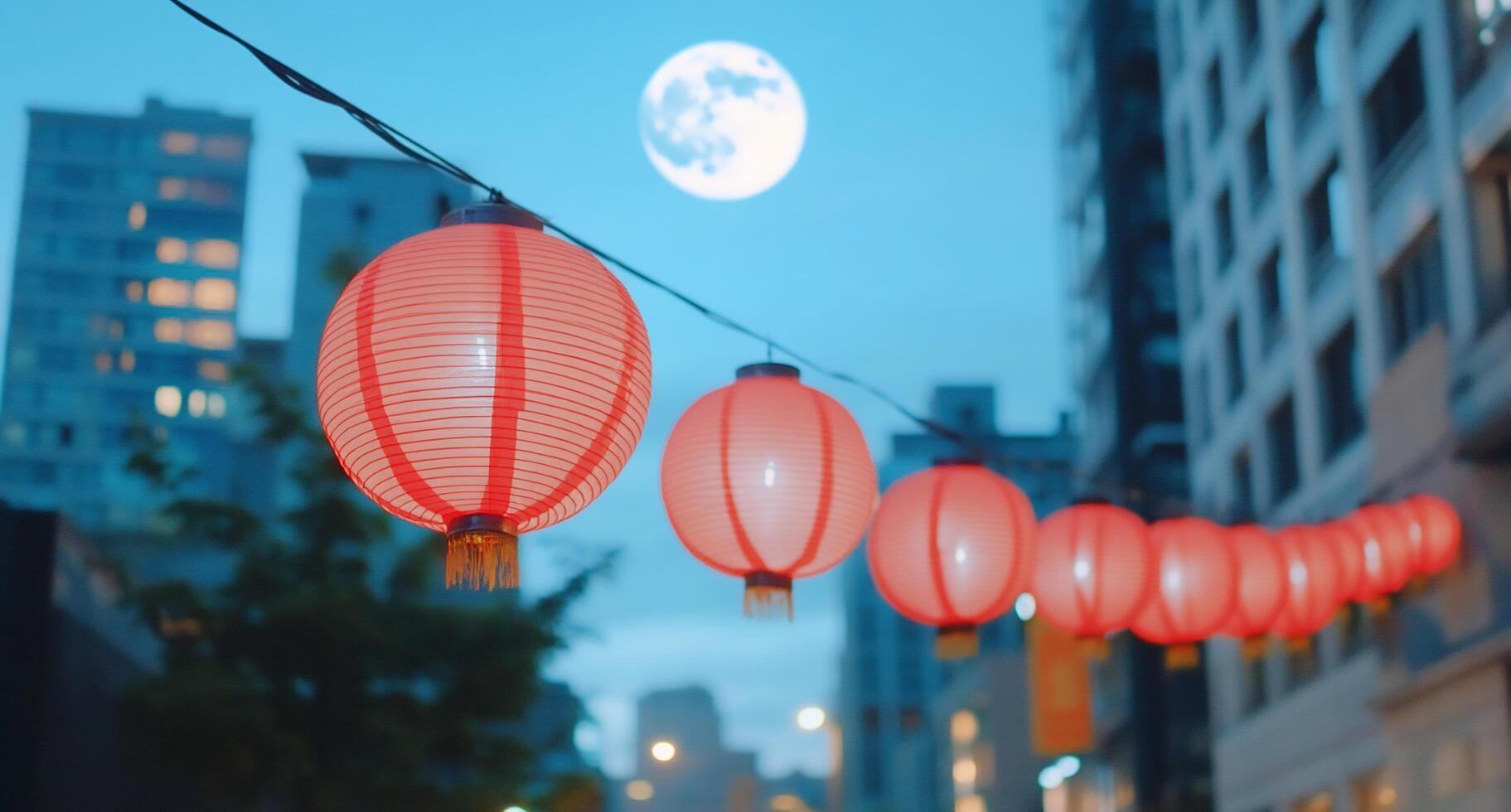 Red lanterns illuminated against a night sky with a full moon. photo