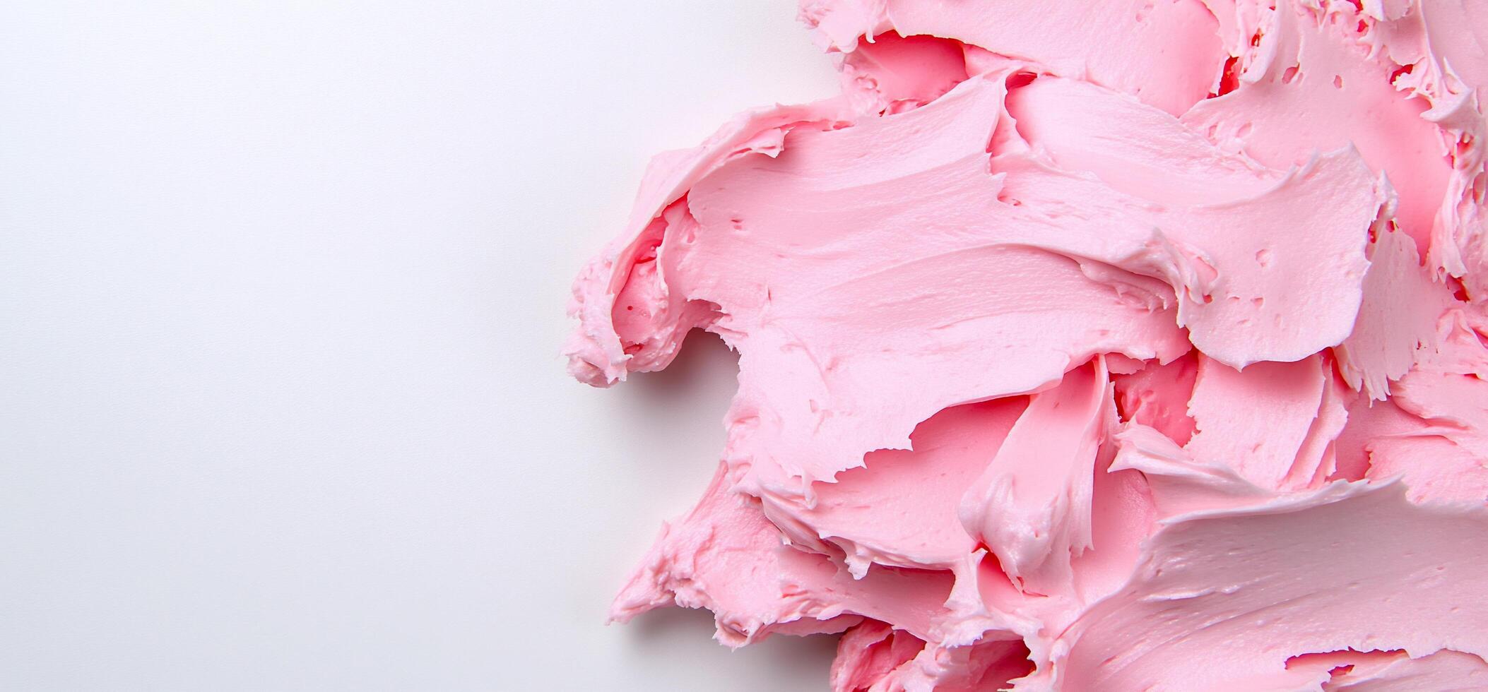 A smooth, pink frosting spread across a white surface. photo