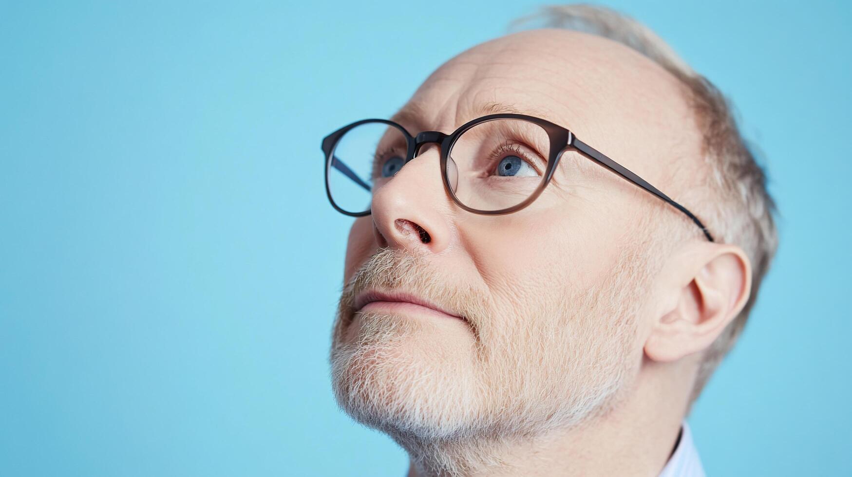 A man with glasses looking up at something photo