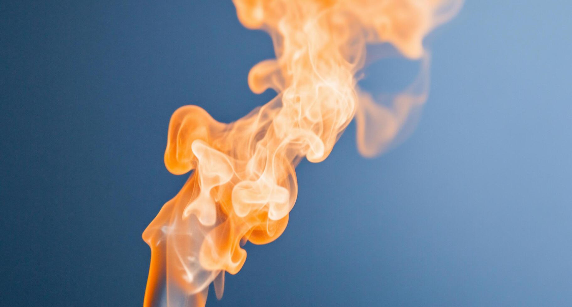 A vibrant swirl of orange flames against a blue background. photo