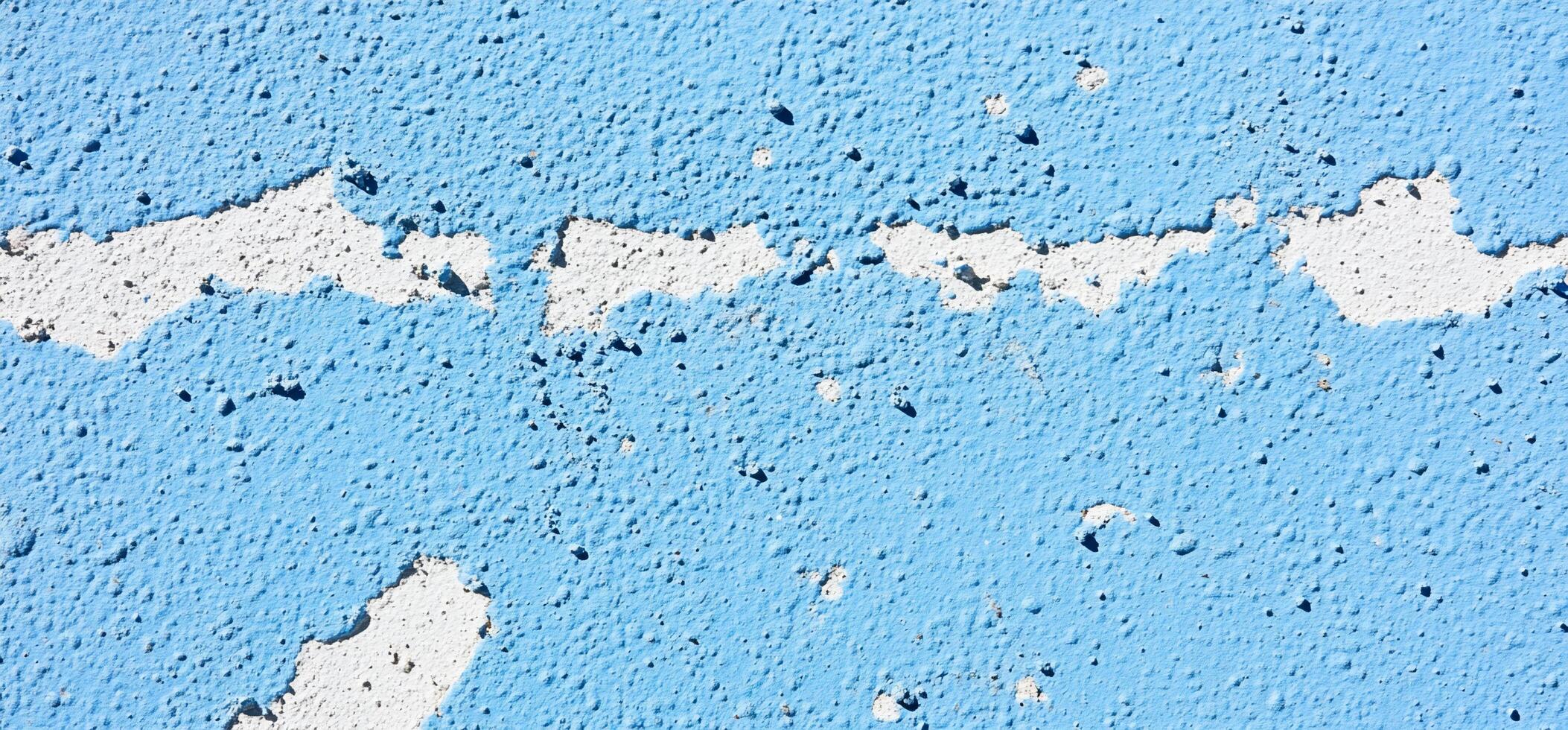 A textured blue wall with peeling paint, showcasing wear and age. photo