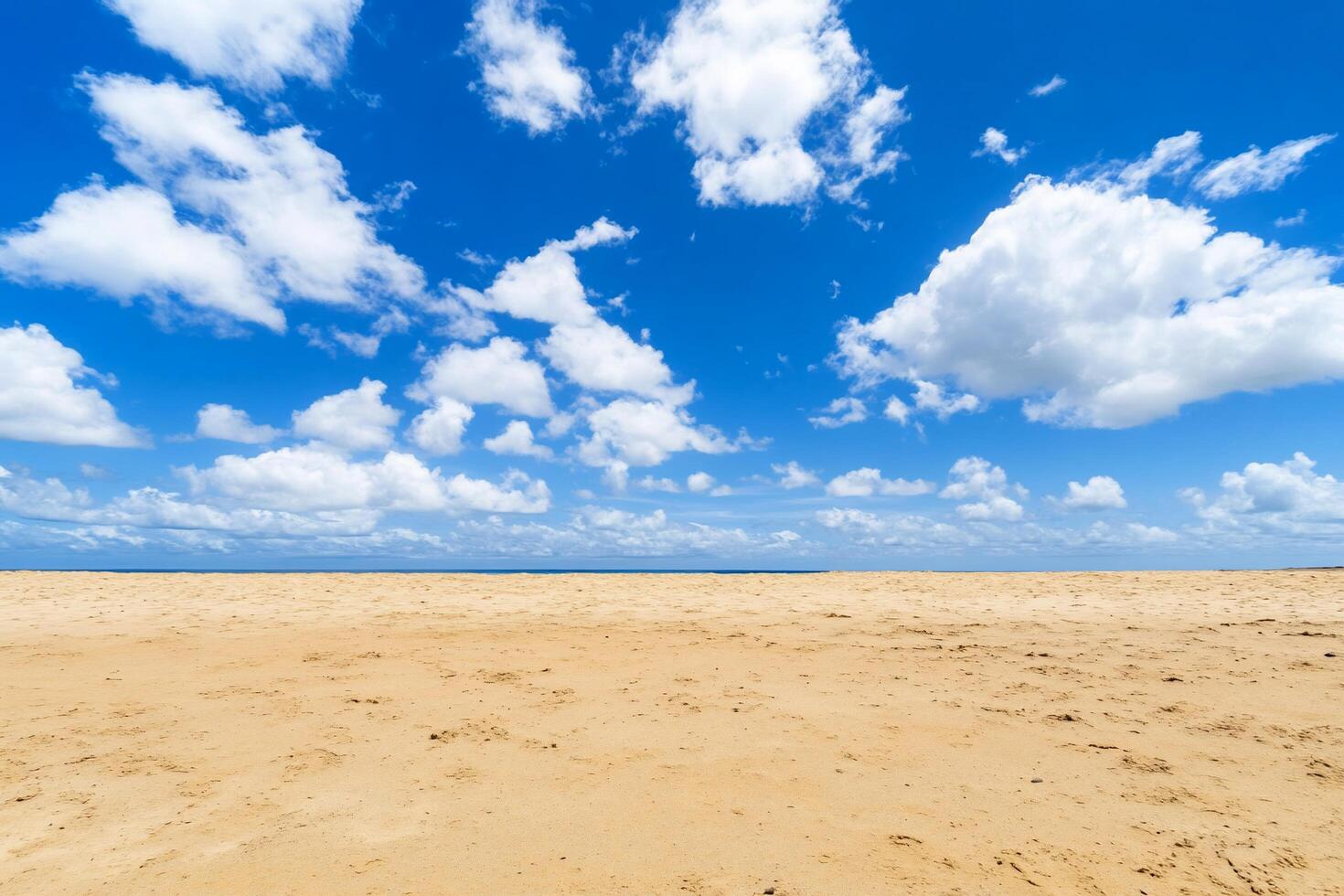 A serene beach scene with golden sand and a bright blue sky. photo