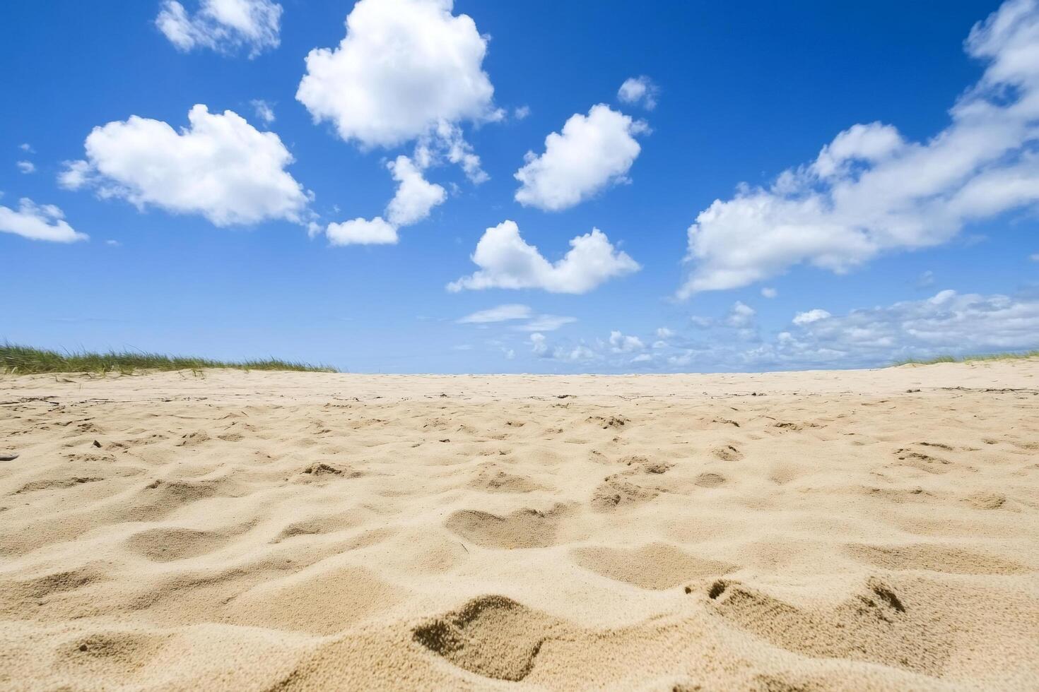 A serene beach scene with soft sand and a clear blue sky. photo