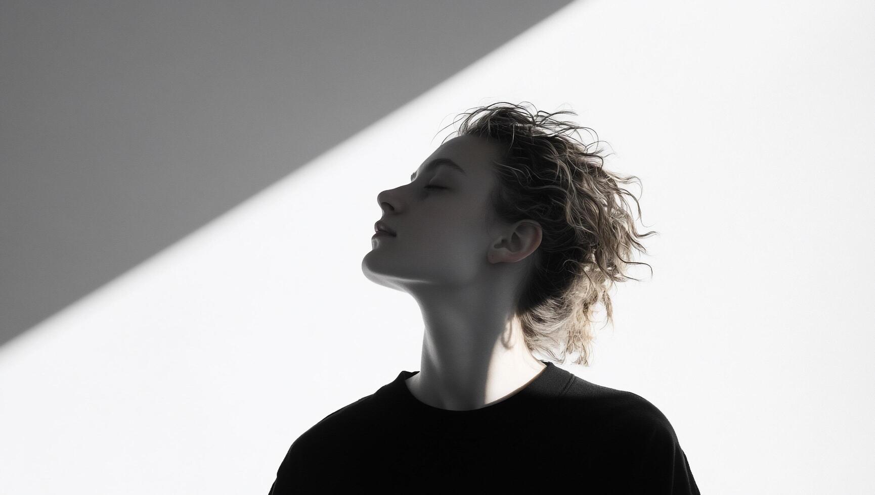A profile silhouette of a person against a stark light backdrop. photo