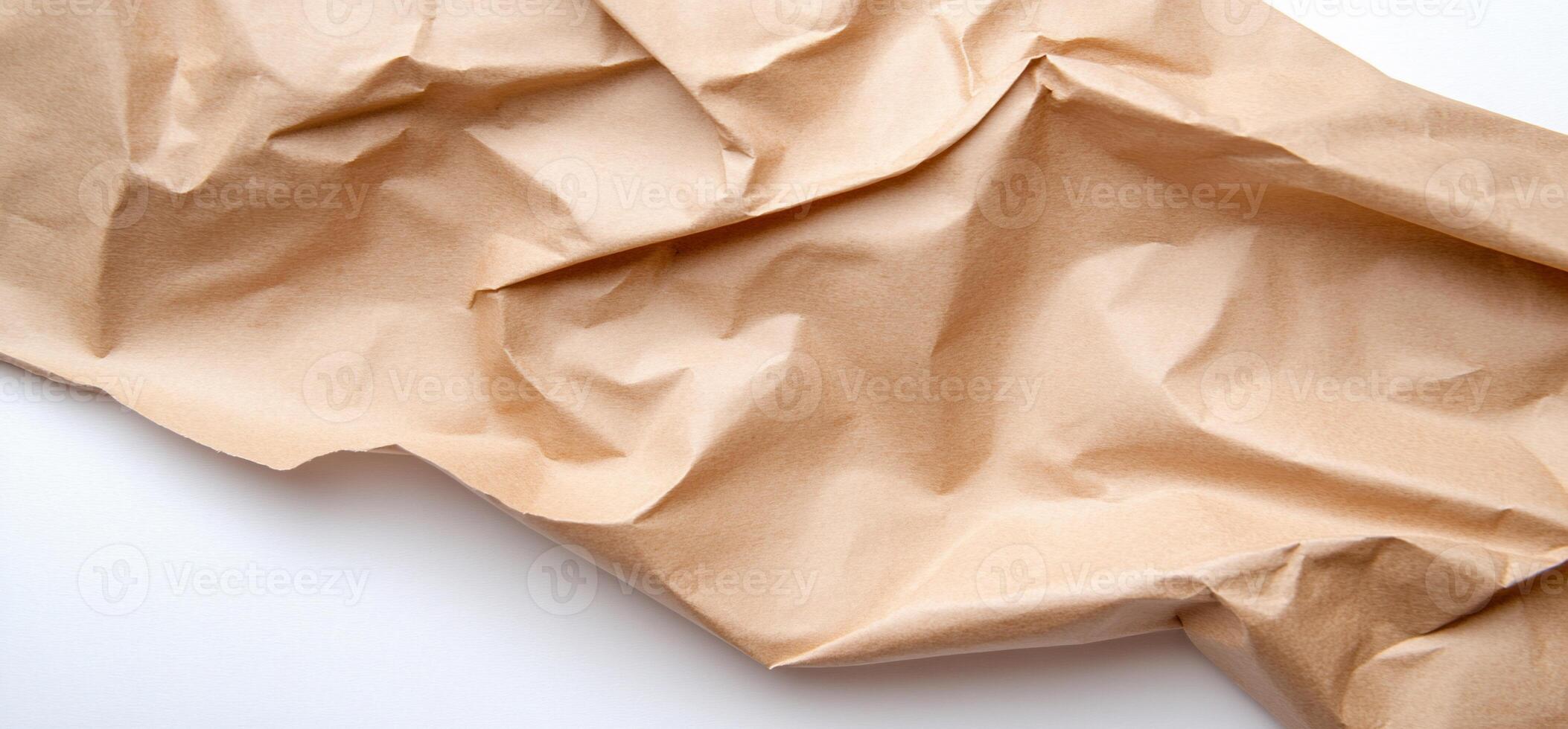 A brown crumpled paper on a white surface photo