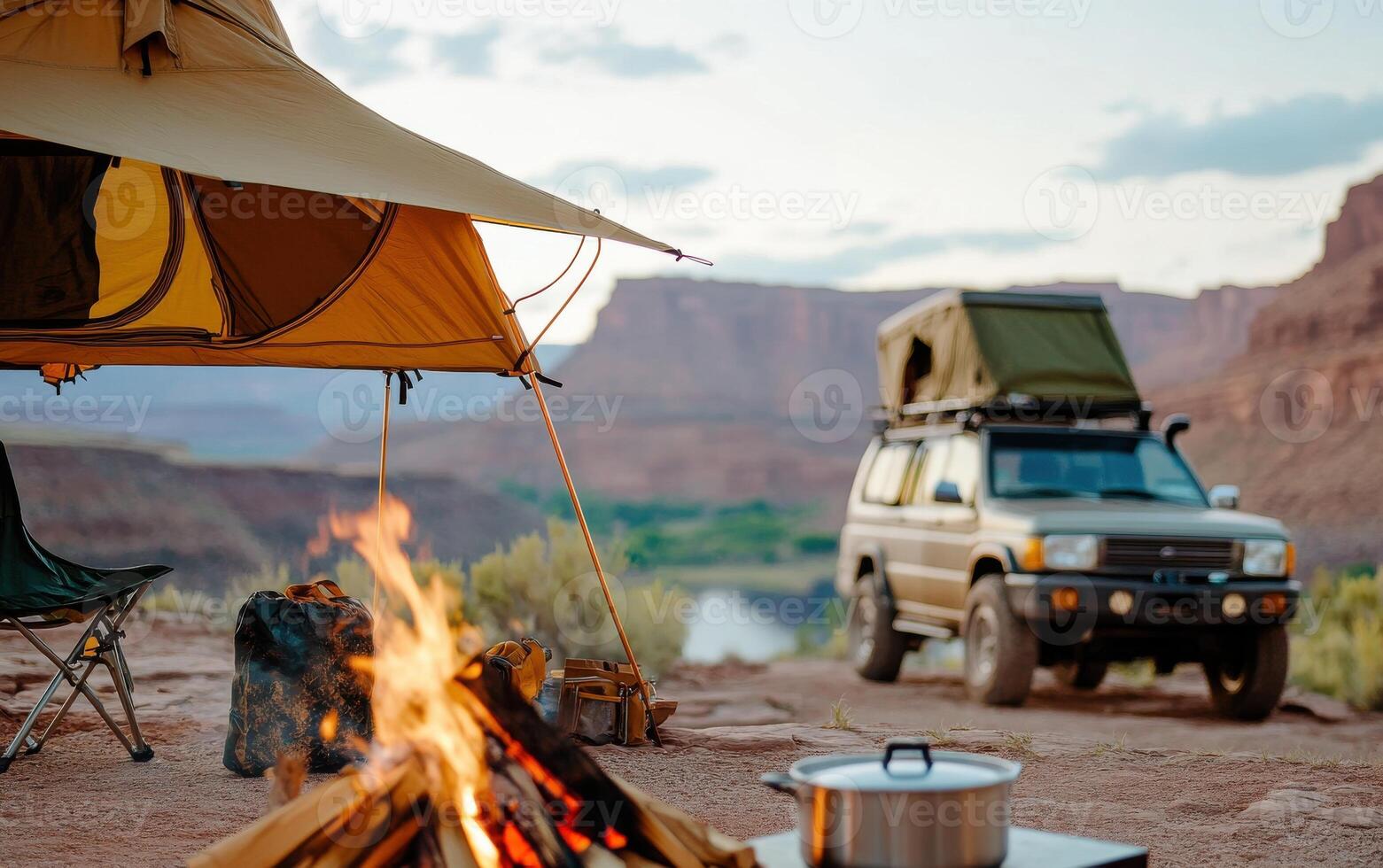 Enjoying a cozy rustic camping setup with a campfire and an SUV near a scenic river at sunset photo