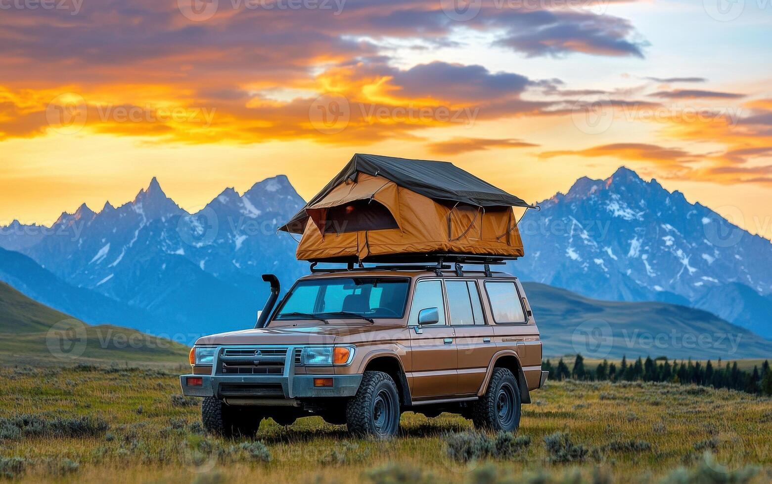 Rugged off-road vehicle with rooftop tent amidst stunning mountain sunset landscape photo