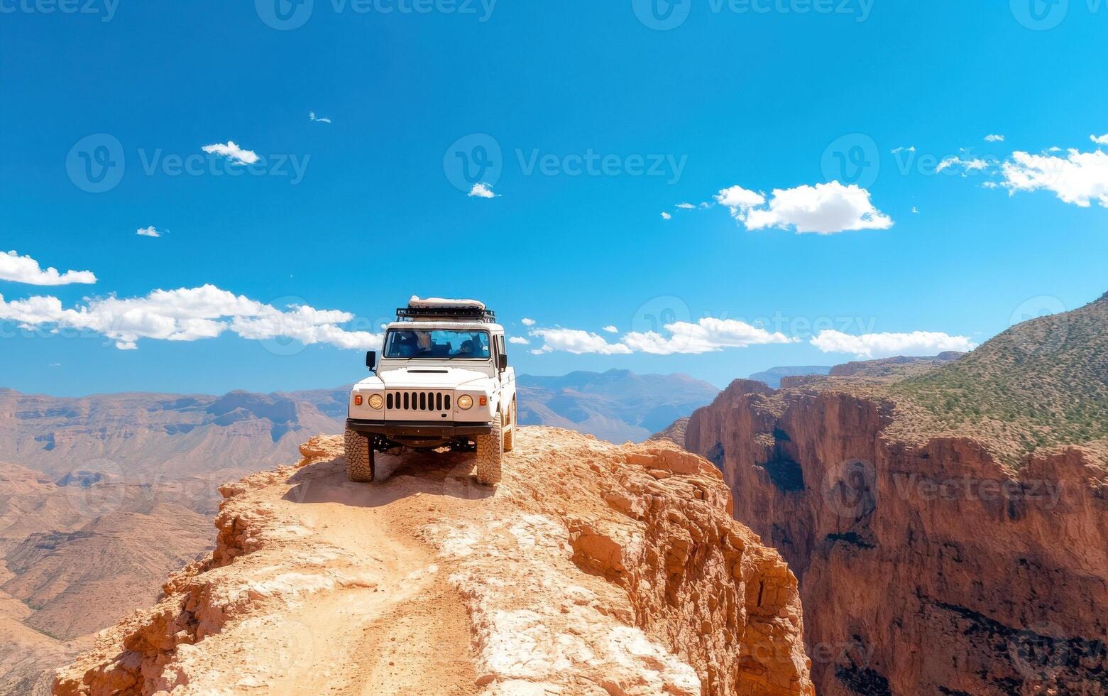 Off-road vehicle navigating rugged terrain in a breathtaking canyon landscape under clear blue skies photo