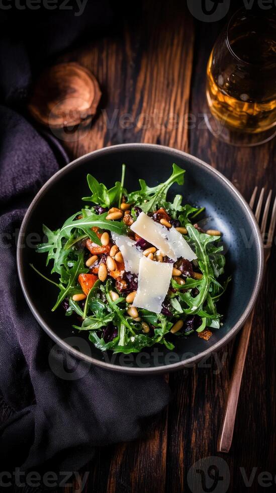 Fresh farm to table salad with arugula, pine nuts, and parmesan served in a rustic setting photo