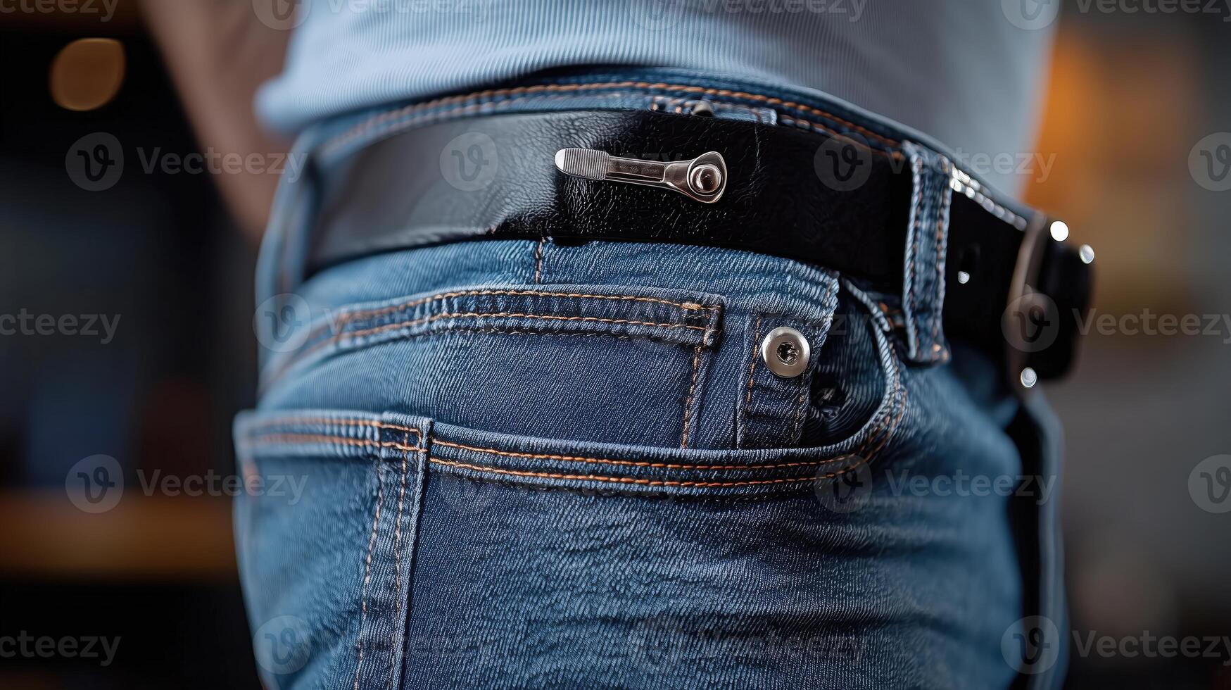 Close-up of a person's hip with a microphone clip attached to a blue jean pocket photo