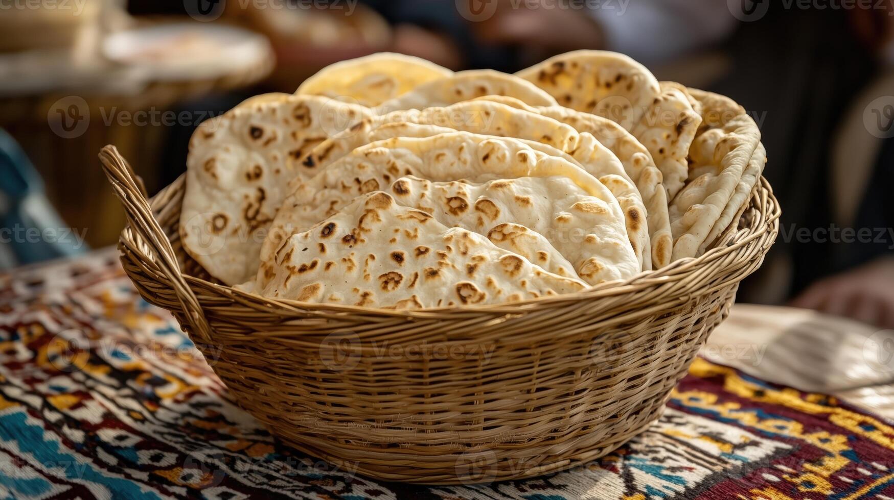 Freshly baked bread in a woven basket on a colorful textile background photo