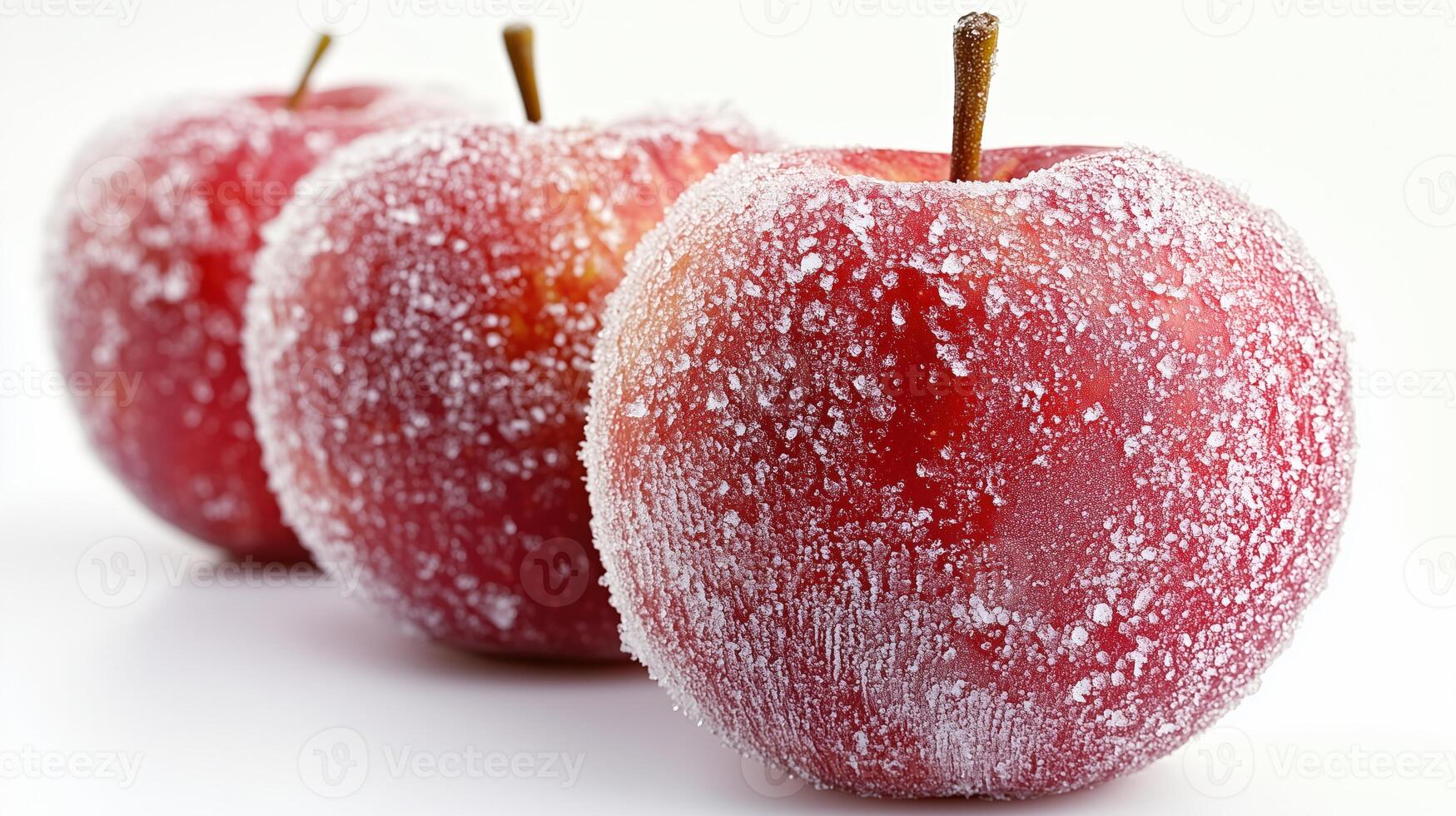 Close-up of three frosted red apples with sugar-like crystals on white background photo