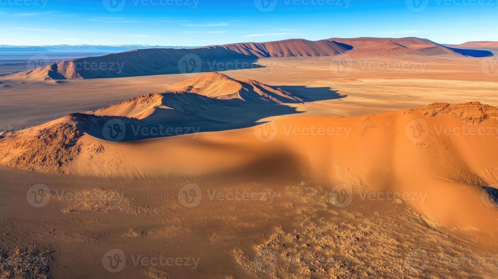 Aerial view of expansive desert landscape with mountain ranges and sand dunes photo
