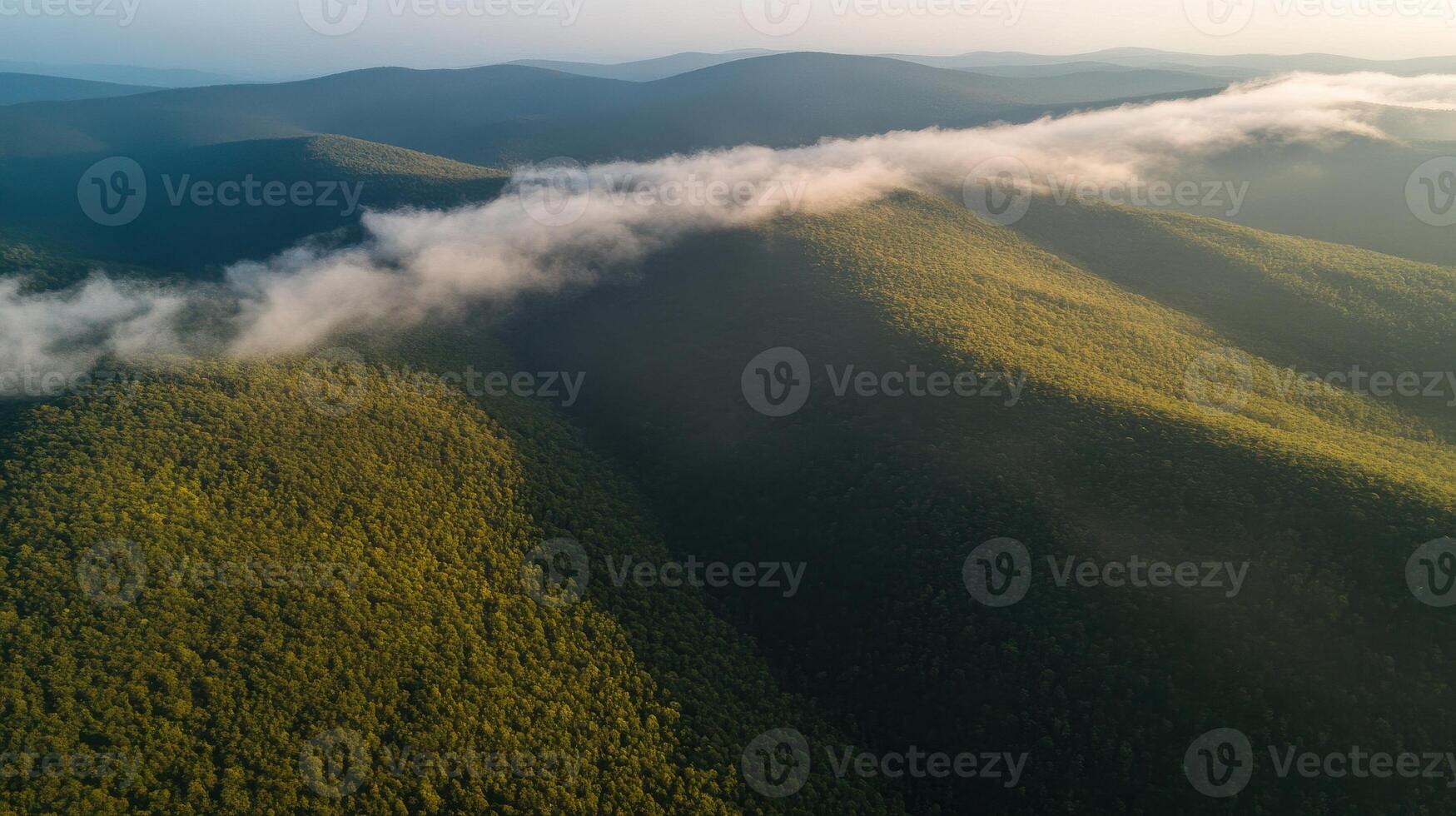 Aerial view of verdant mountain range with rolling clouds at sunset photo