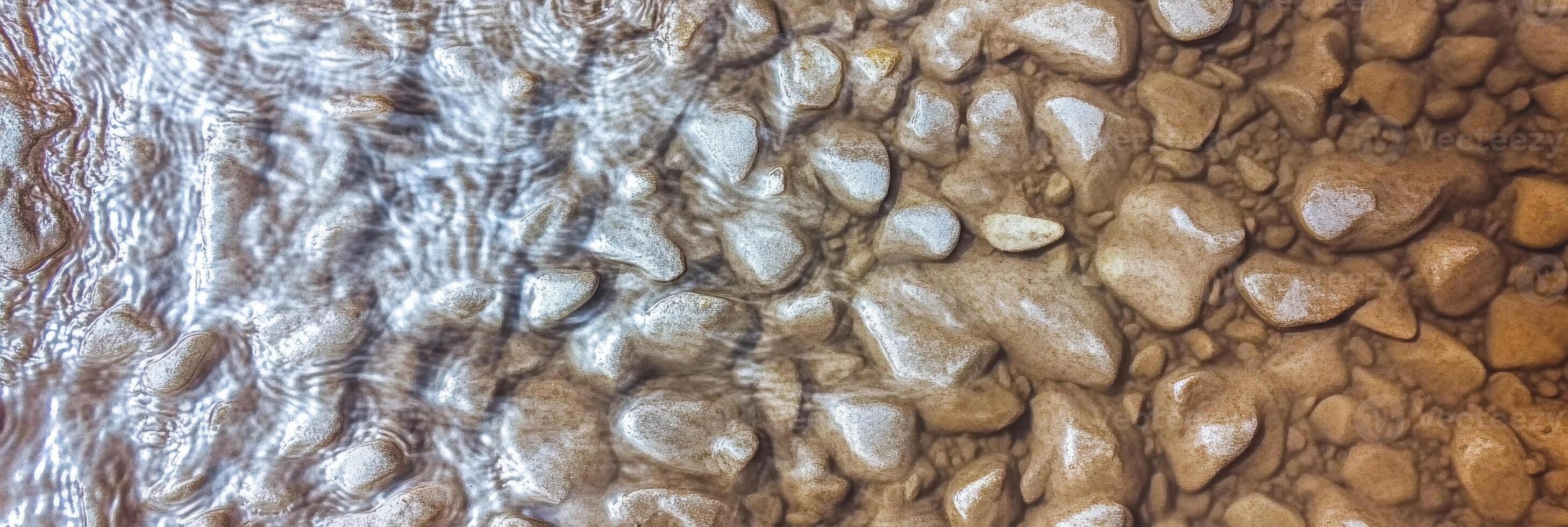Rippling water flowing over smooth river stones in natural streambed pattern photo