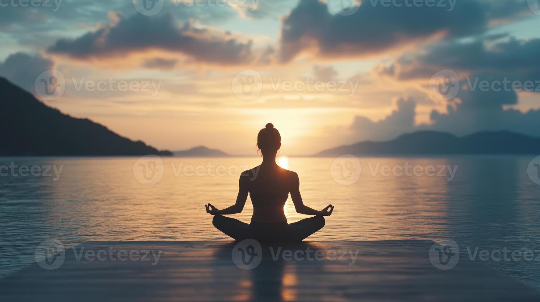 Woman meditating at sunset on a dock, finding inner peace and balance photo