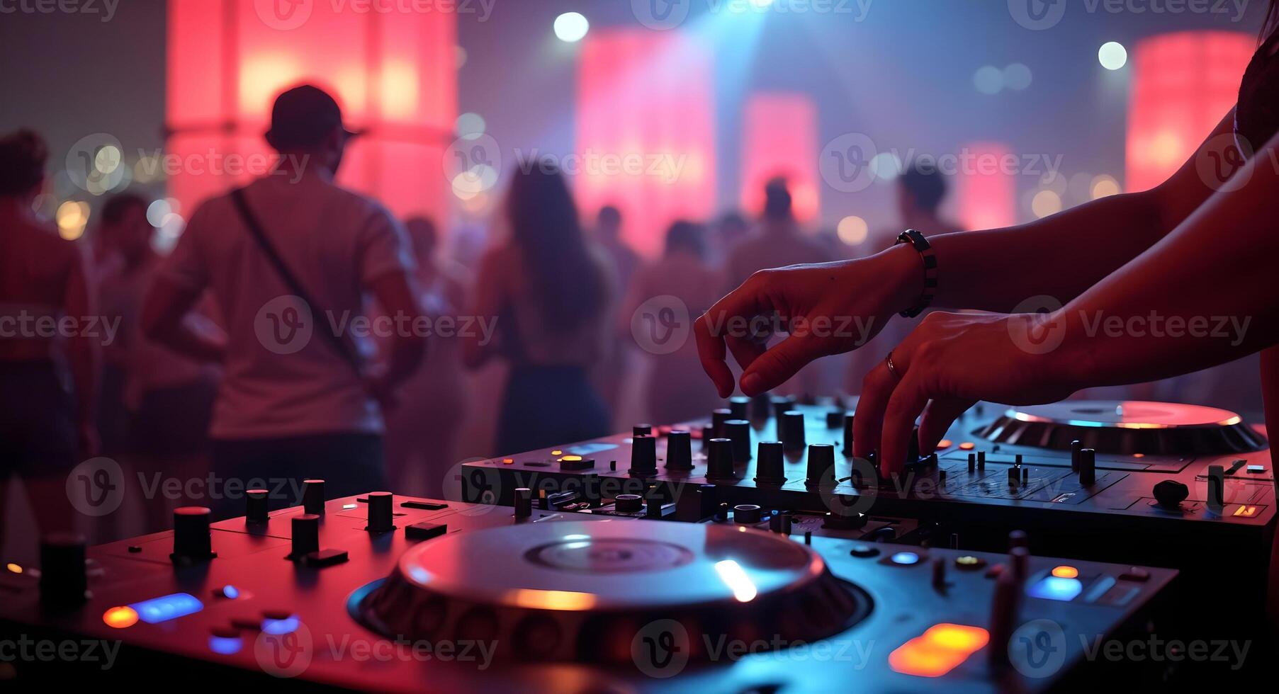 DJ mixing music at a lively party with vibrant lights and crowd photo