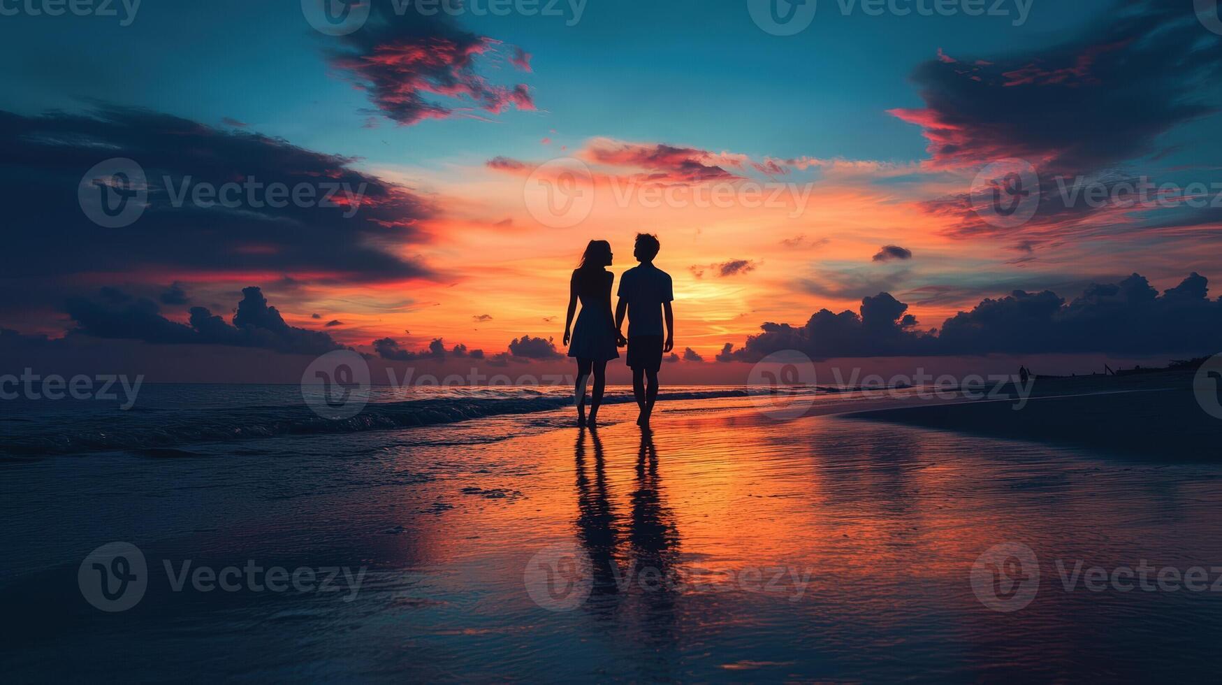 Romantic couple walking on beach at sunset holding hands together photo