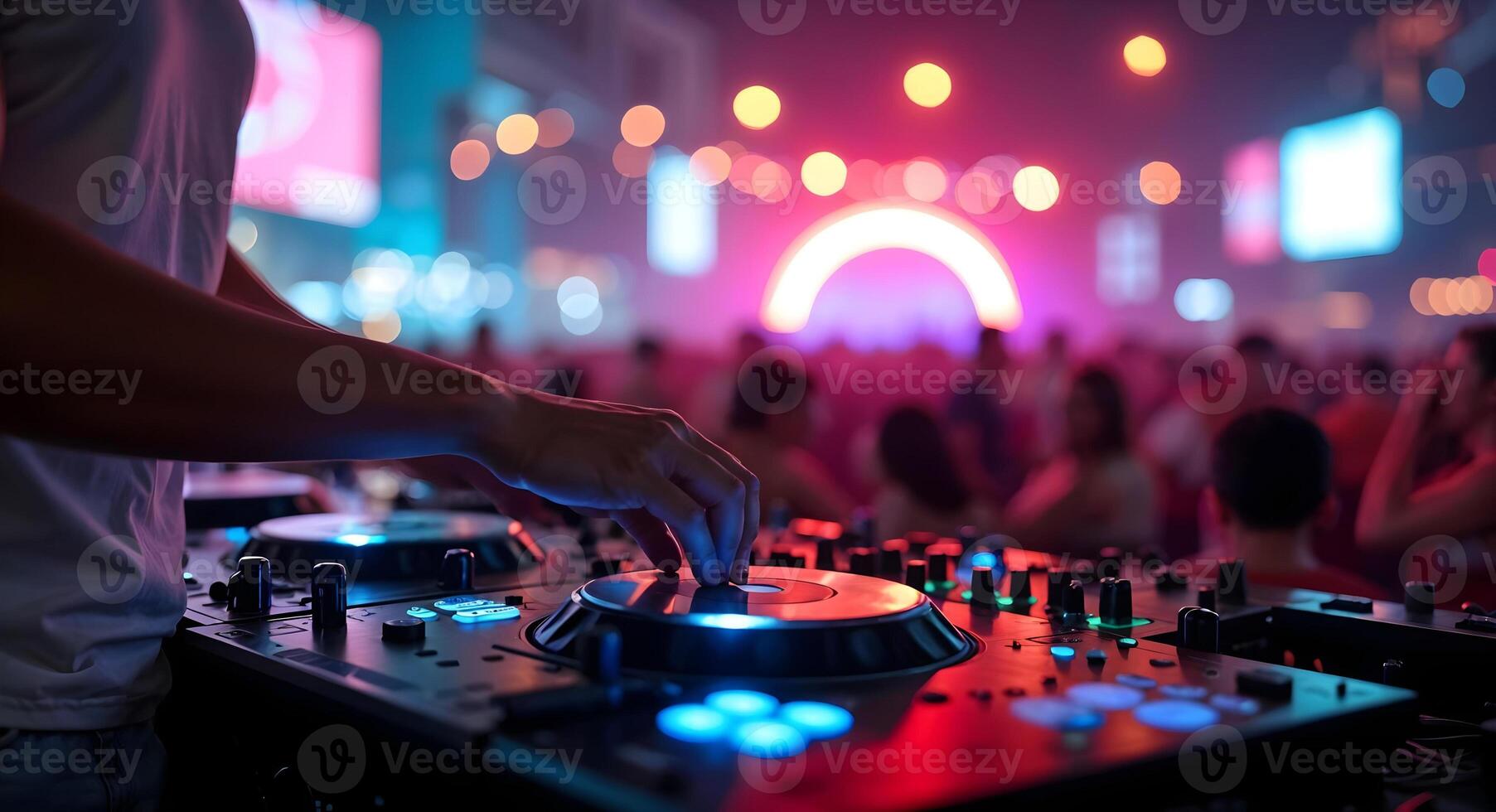 DJ mixing music at a party with colorful lights and crowd photo