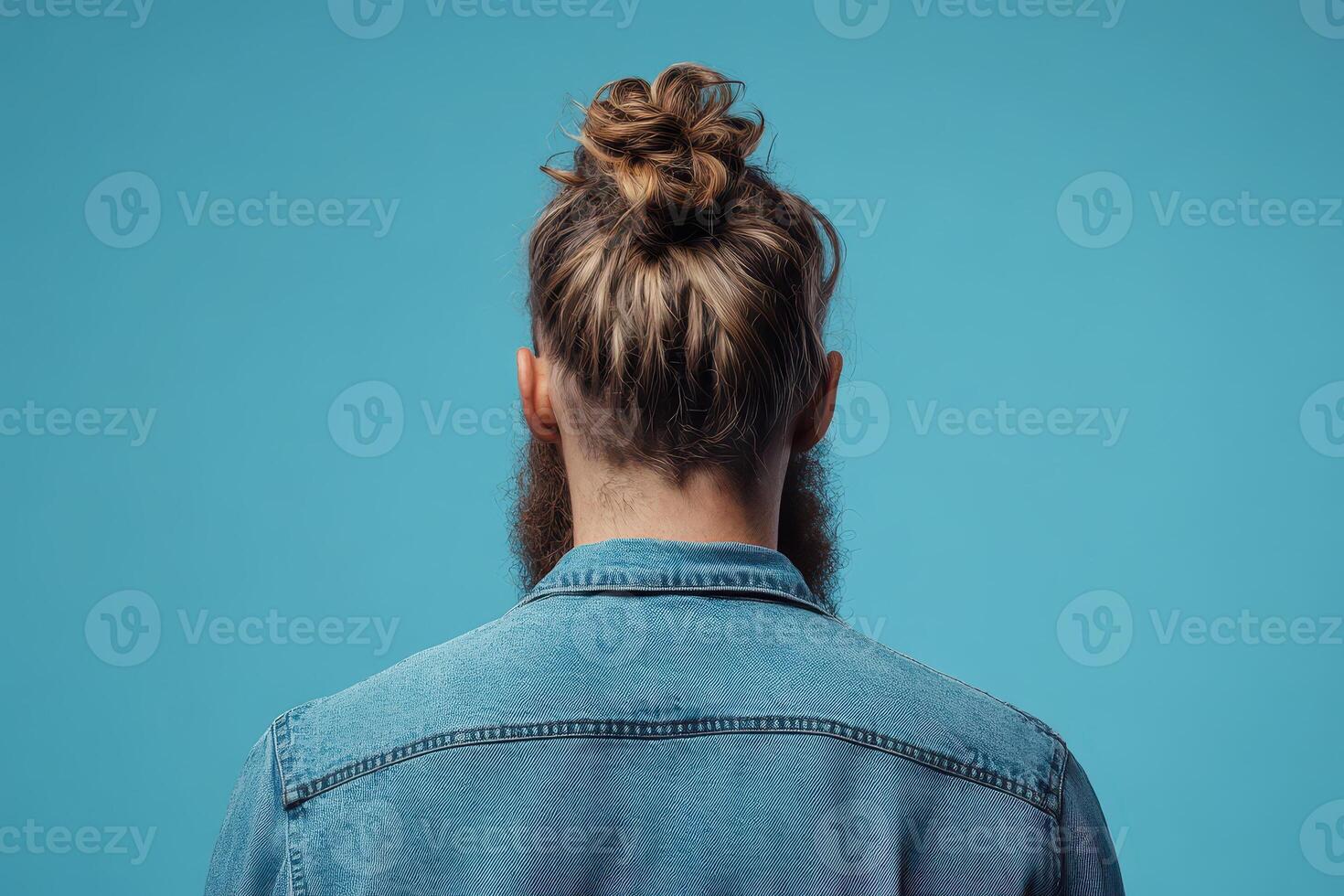 A man with a messy bun in his hair photo